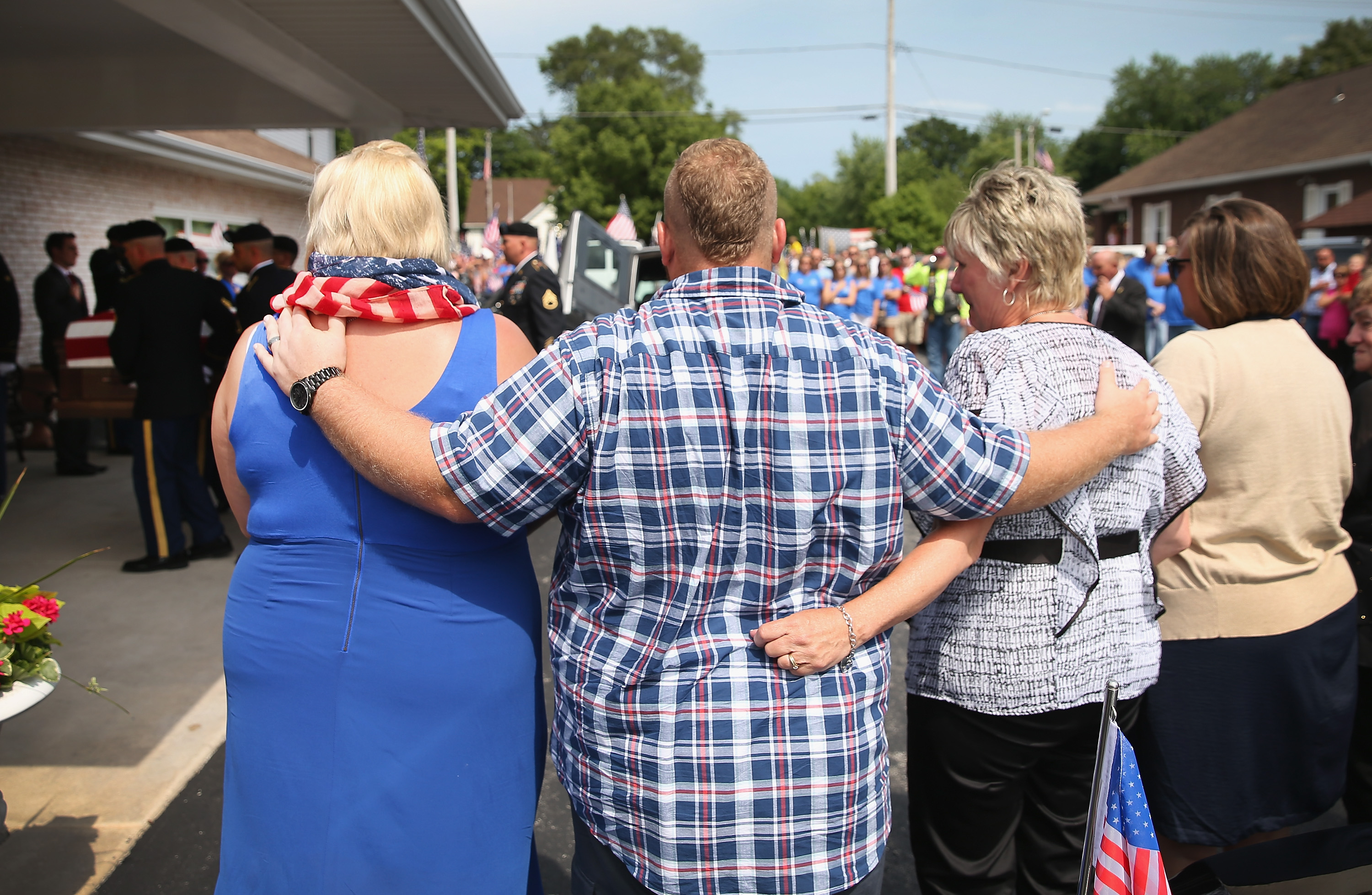 Family members watch as the remains of Army Pfc. Aaron Toppen are carried into the funeral home on June 21, 2014 in Mokena, Ill.