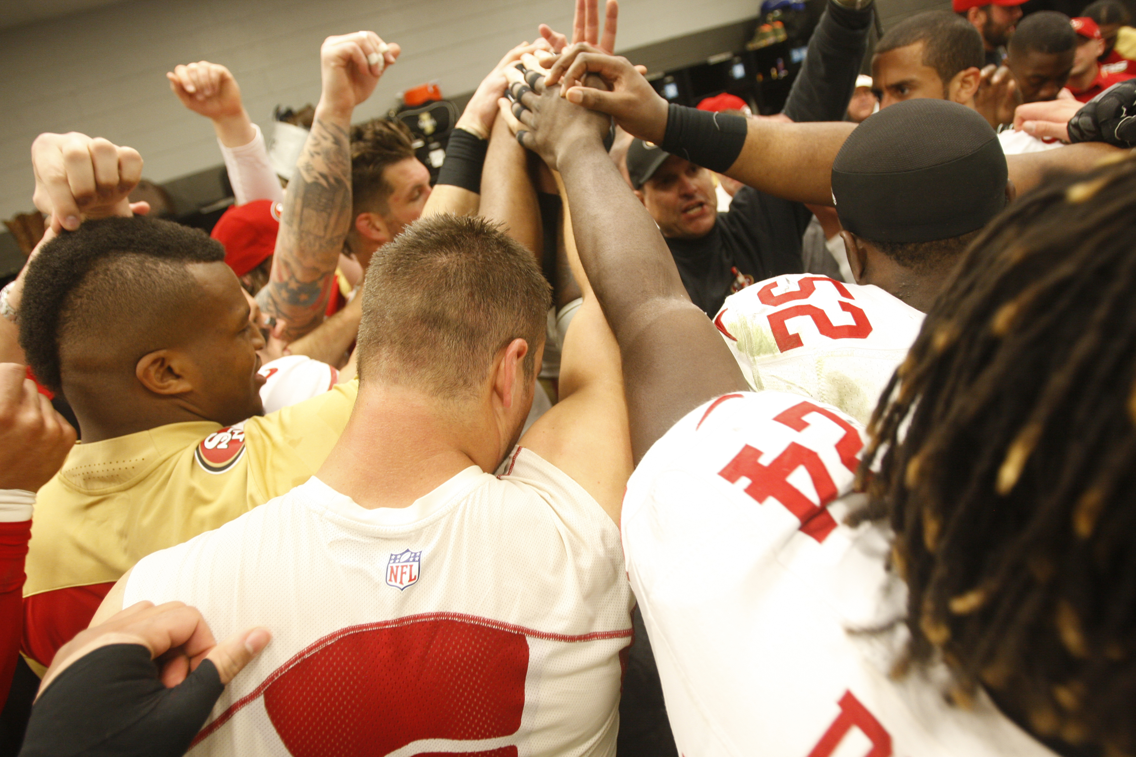 The San Francisco 49ers chant in the locker room following the game against the Carolina Panthers at Bank of America Stadium on January 12, 2014 in Charlotte, North Carolina. (Michael Zagaris—Getty Images)