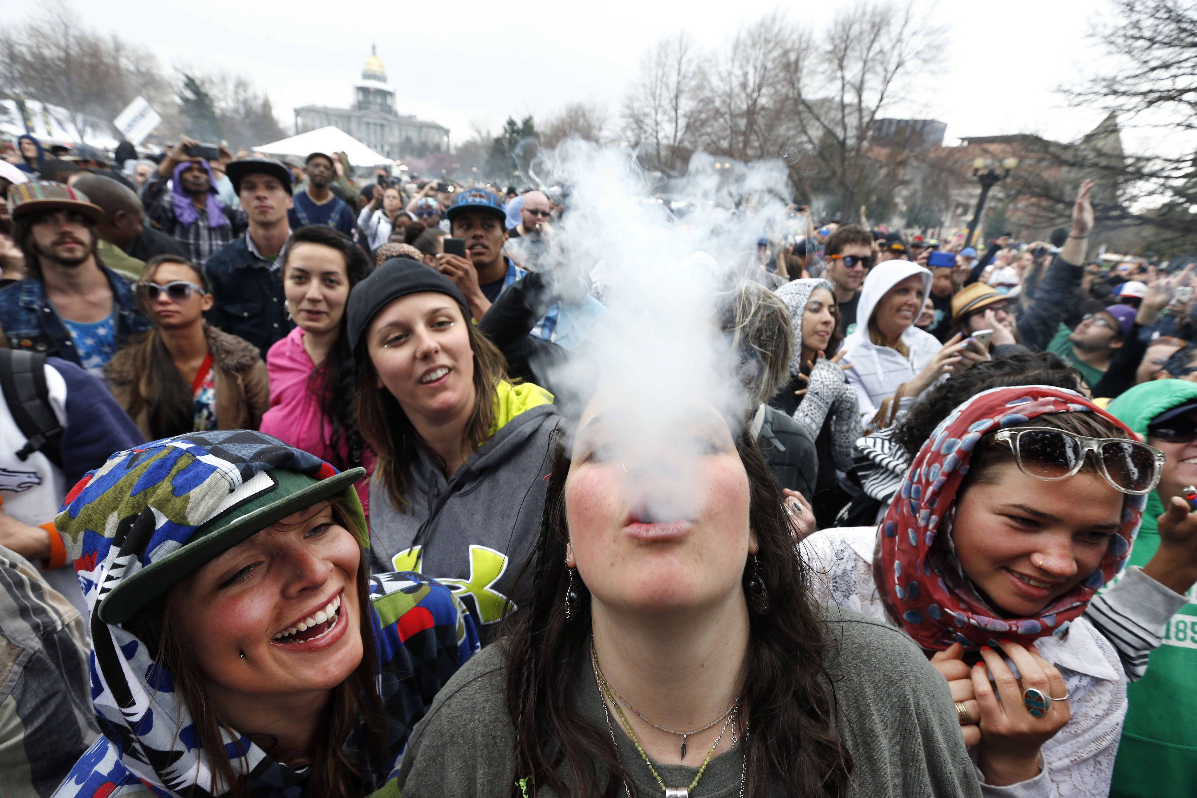 With the Colorado state capitol building visible in the background, partygoers dance and smoke pot on the first of two days at the annual 4/20 Marijuana Festival in Denver, April 19, 2014. (Brennan Linsley—AP)