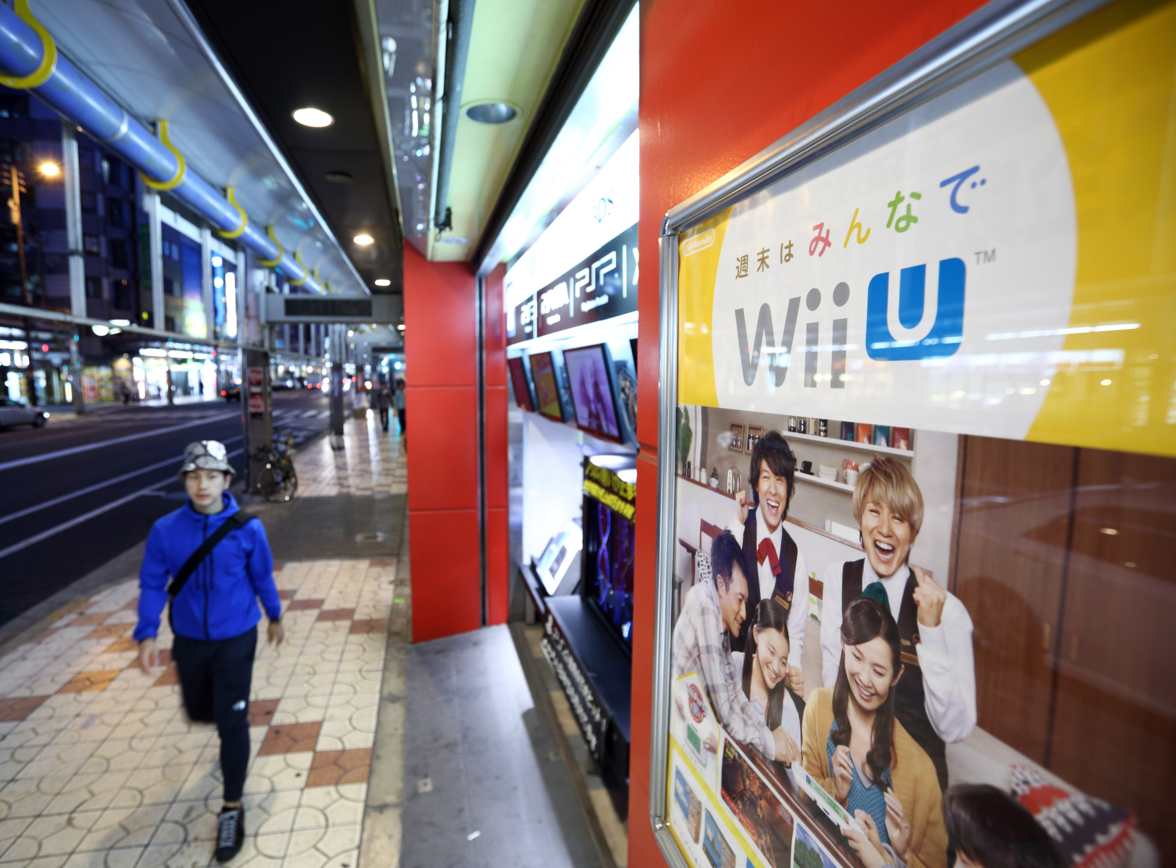 A pedestrian walks past an advertisement for Wii U, Nintendo's gaming console, outside a store in the Japanese city of Osaka on May 2, 2014 (Tomohiro Ohsumi—Bloomberg/Getty Images)