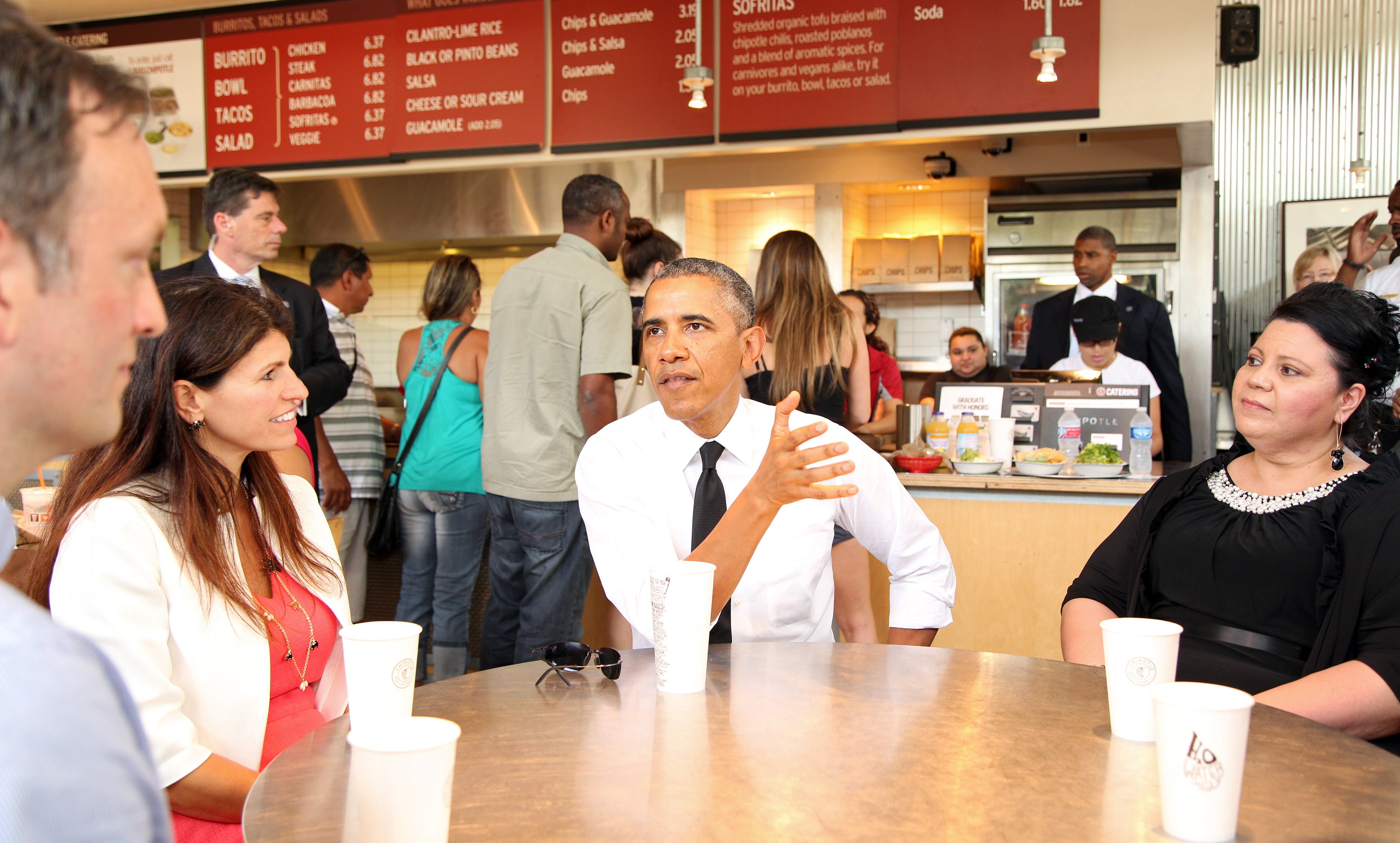 President Barack Obama joins several working parents, (l-r) Roger Trombley, Lisa Rumain, and Shelby Ramirez for lunch at a nearby Chipotle restaurant prior to speakinging at the first White House Summit on Working Families at the Omni Hotel in Washington, June 23, 2014. (Martin H. Simon—Corbis)