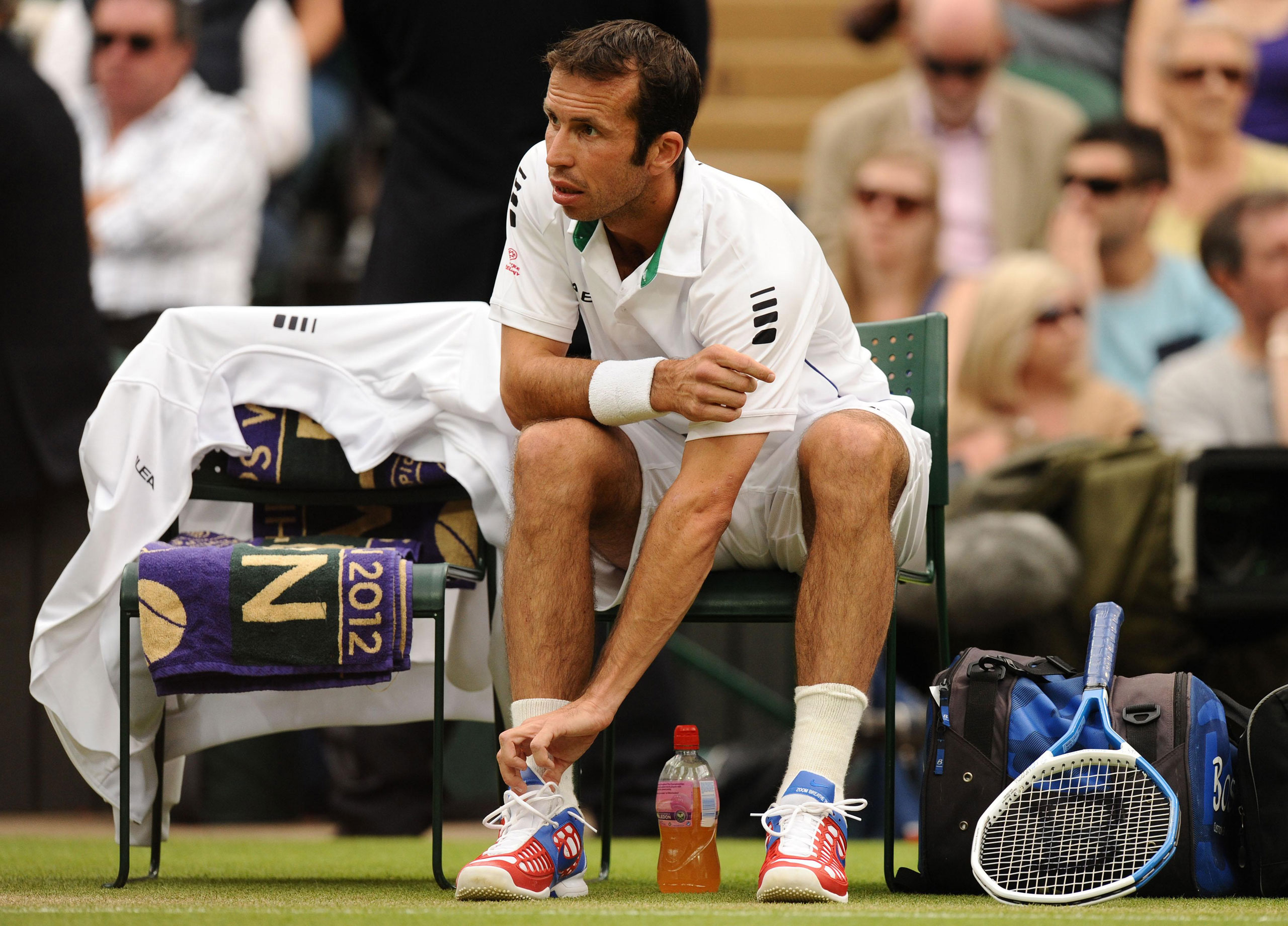 Radek Stepanek changes his sneakers before his match against Novak Djokovic at the 2012 Wimbledon Championships. The shoes were deemed too bright for the all-white dress code.