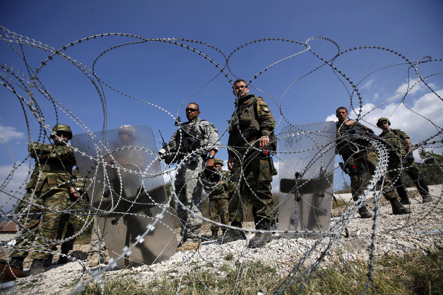 Kosovo Force soldiers from Greece, Germany and the U.S. stand guard at the closed Serbia-Kosovo border crossing of Jarinje on Sept. 29, 2011. (Marko Djurica— Reuters)
