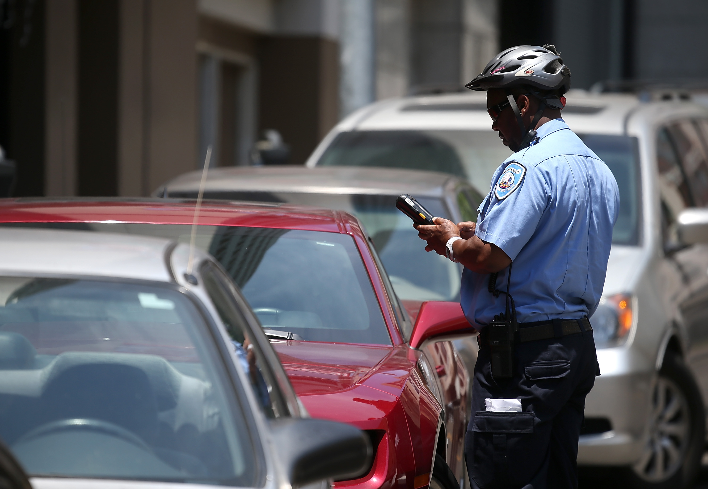 A San Francisco Municipal Transportation Agency parking control officer writes a parking ticket for an illegally parked car on July 3, 2013 in San Francisco. (Justin Sullivan—Getty Images)