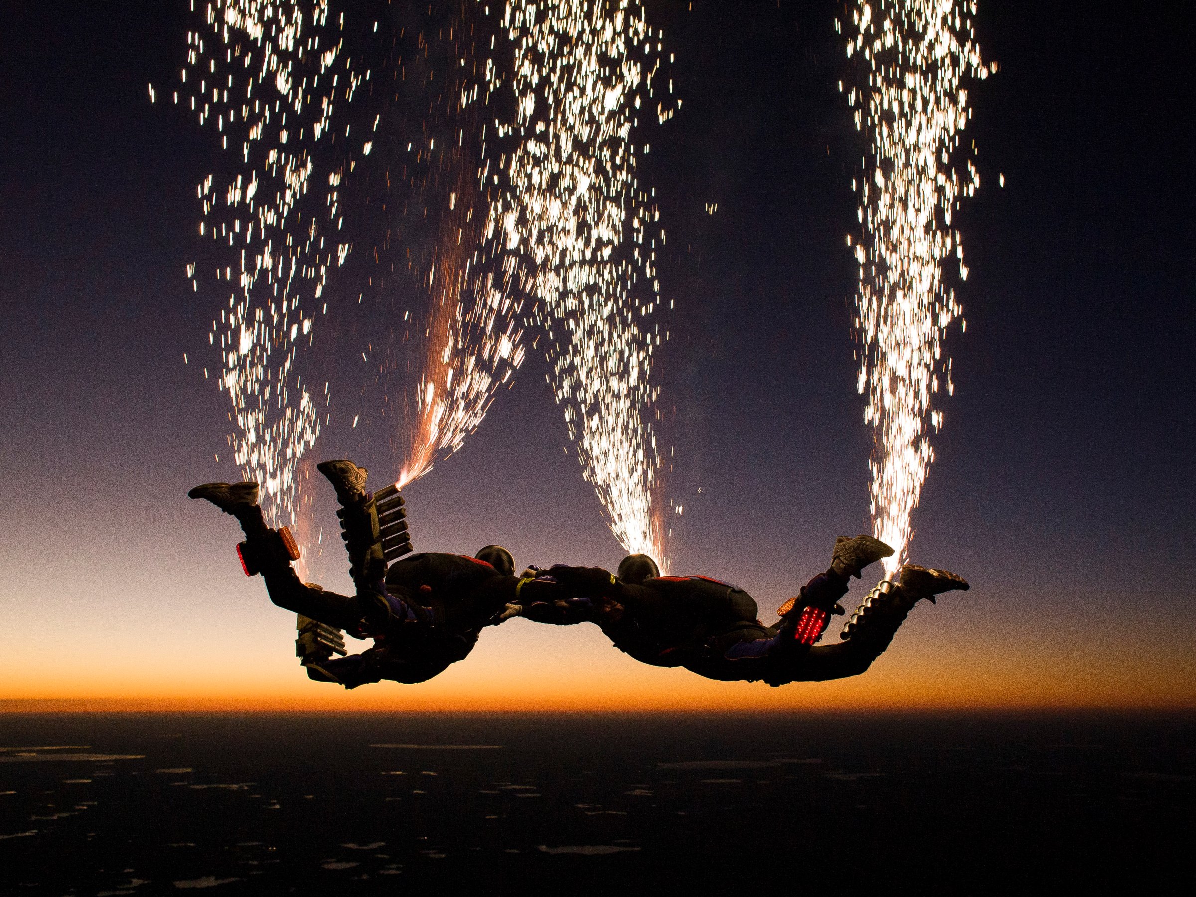 The Fastrax skydiving team set off fireworks as they jump out of the plane.