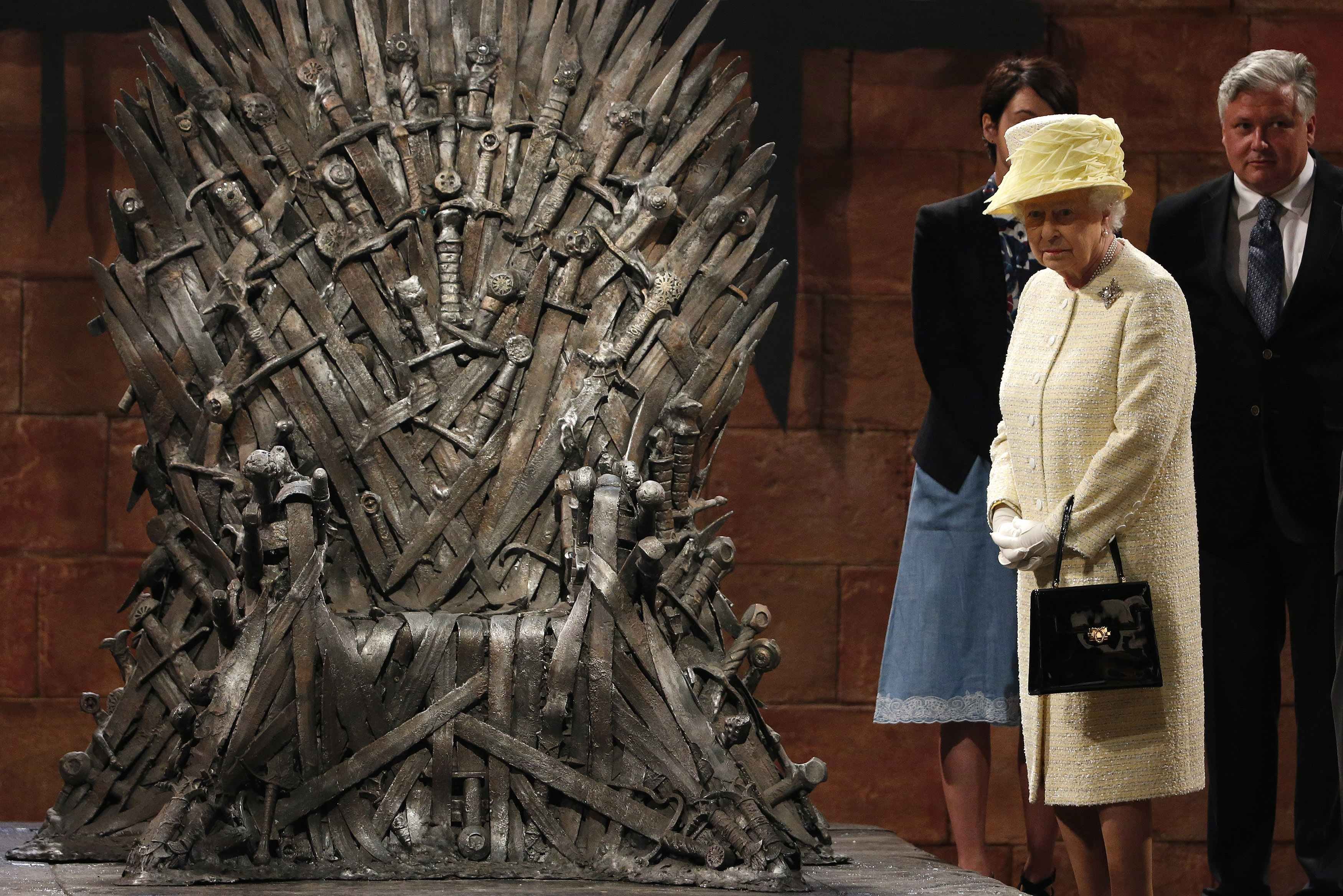 Britain's Queen Elizabeth looks at the Iron Throne as she meets members of the cast on the set of the television show Game of Thrones in the Titanic Quarter of Belfast, Northern Ireland, June 24, 2014.