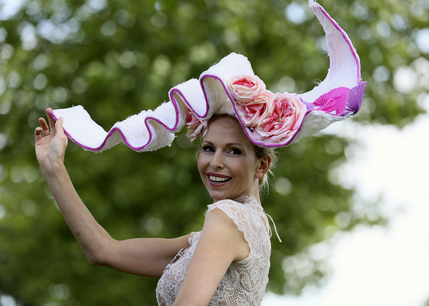 Anneka Tanaka-Svenska poses for photographers with a hat by milliner Louis Mariette on the first day of the Royal Ascot horse racing festival at Ascot, June 17, 2014.