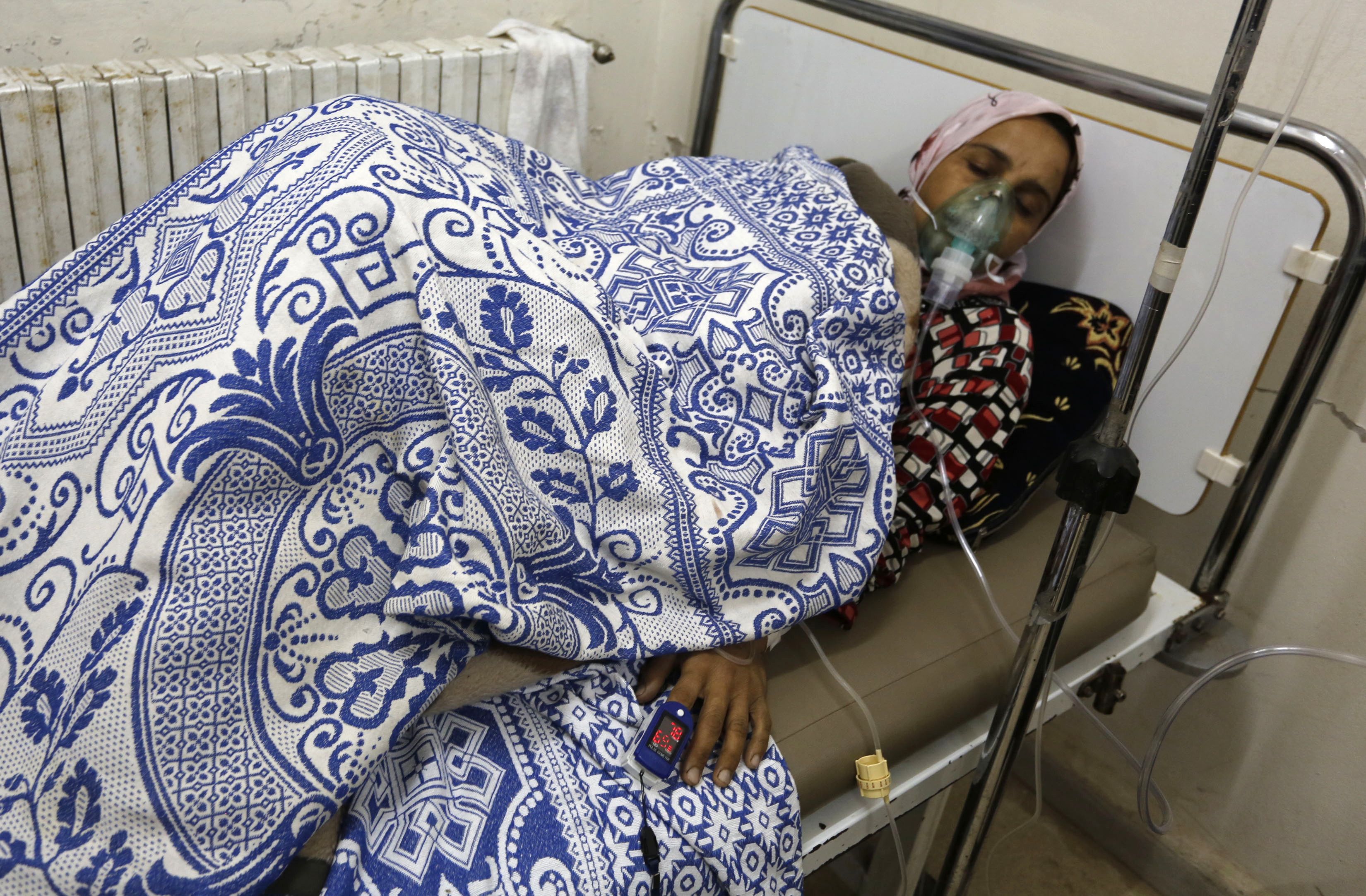 A woman, affected by what activists say was a gas attack, receives treatment inside a makeshift hospital in Kfar Zeita village in Hama