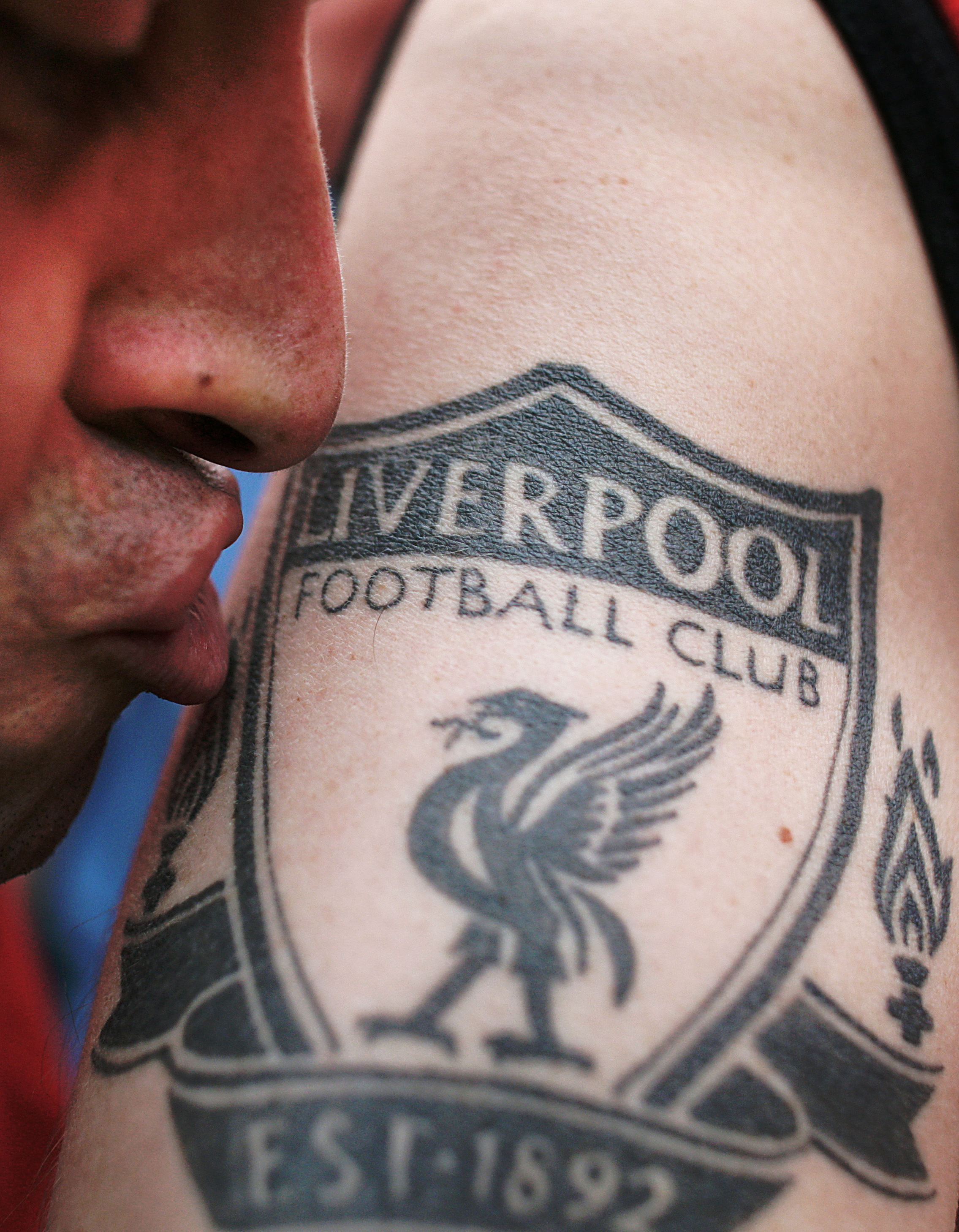 A Liverpool fan kisses a tattoo with the Liverpool soccer club's emblem outside a pub before the Champions League final match between AC Milan and Liverpool on May 24, 2005 in Istanbul.