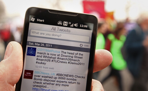 A smartphone displays the Metropolitan Police's Twitter feed during a 2011 protest against government guts in London. Companies are increasingly turning to monitoring social media to improve their businesses. (Peter Macdiarmid—Getty Images)