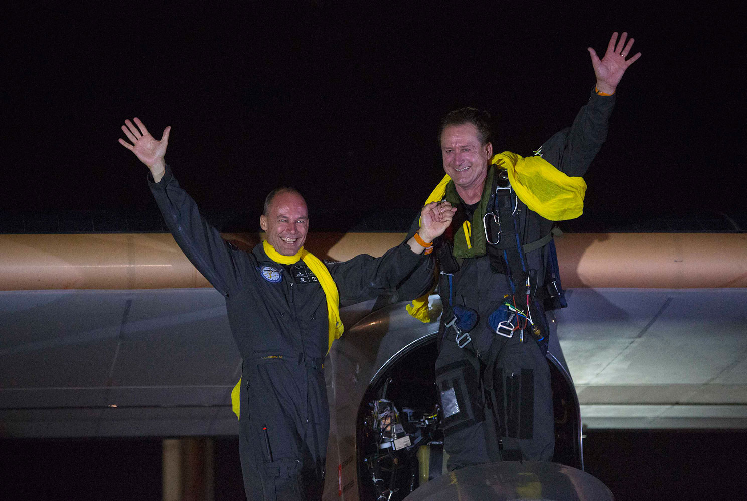 Pilots and founders Bertrand Piccard and Andre Borschberg, right, wave to the crowd after Solar Impulse lands at JFK airport in New York July 6, 2013. The airplane entirely powered by the sun touched down in New York City late on Saturday, completing the final leg of an epic journey across the United States that began over two months ago.