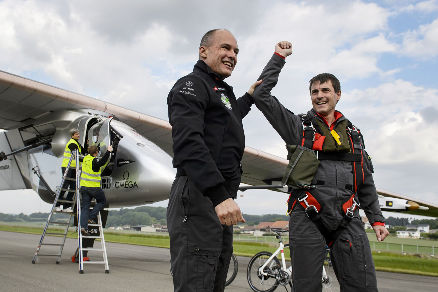 From left: Solar Impulse co-founder Bertrand Piccard congratulates German test pilot Markus Scherdel after Solar Impulse 2's maiden flight from Payerne on June 2, 2014.