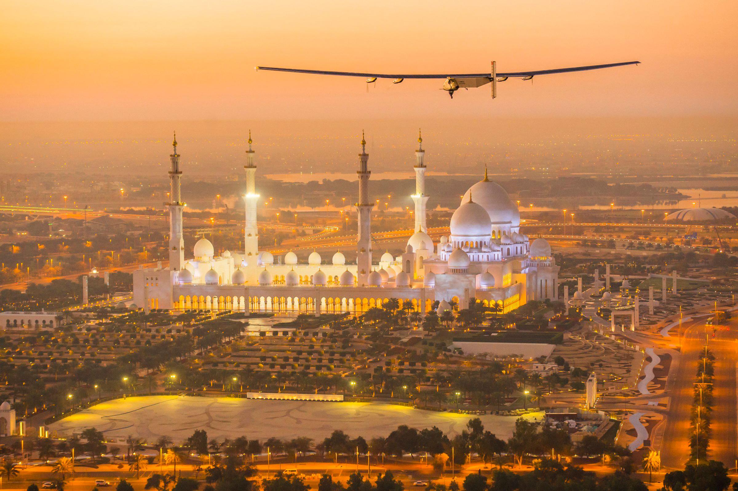 The Solar Impulse 2, a solar-powered plane, flies over the Sheikh Zayed Grand Mosque in Abu Dhabi during preparations for next month's round-the-world flight on Feb. 26, 2015.