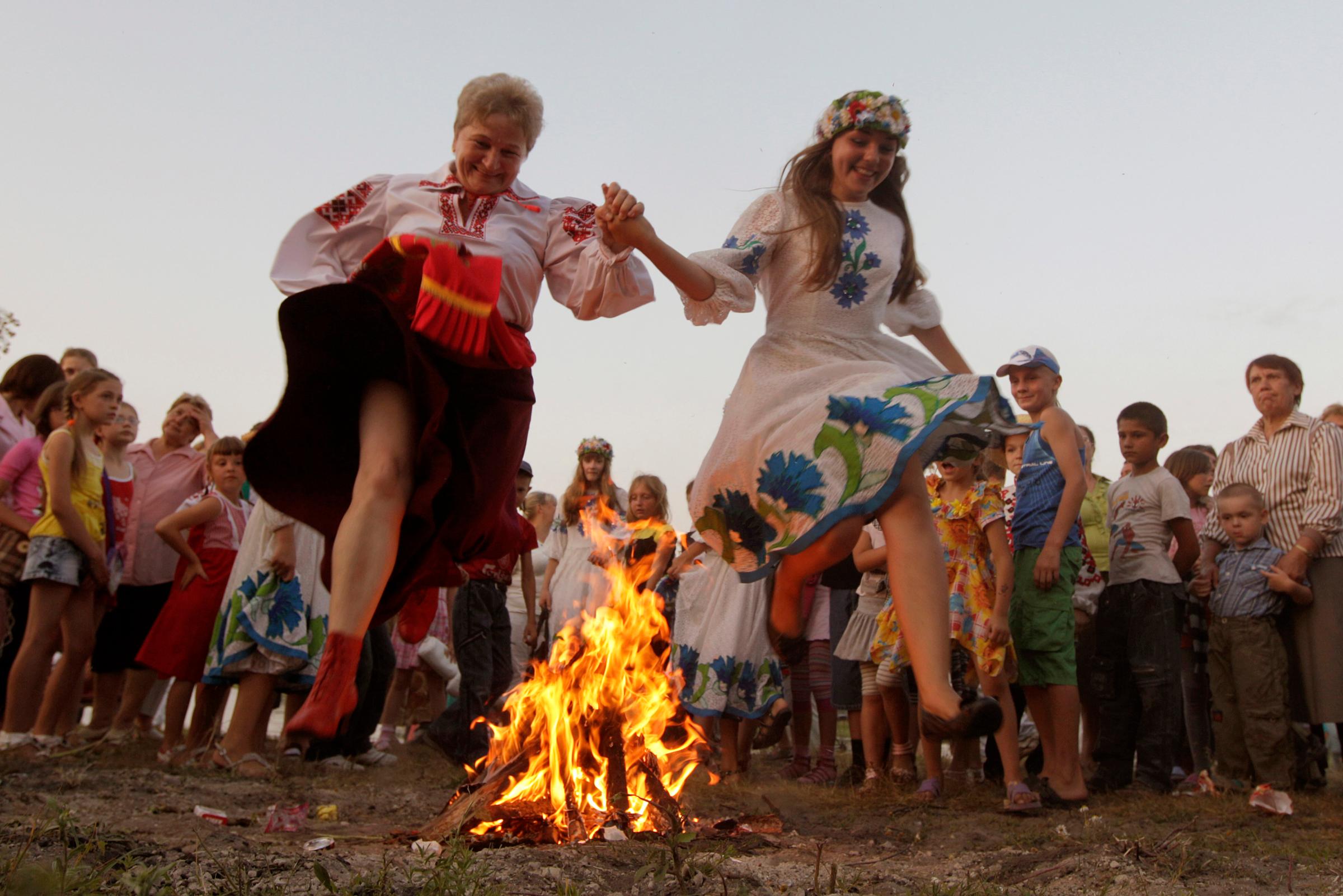 Women jump over a campfire during the Ivan Kupala festival in the town of Turov