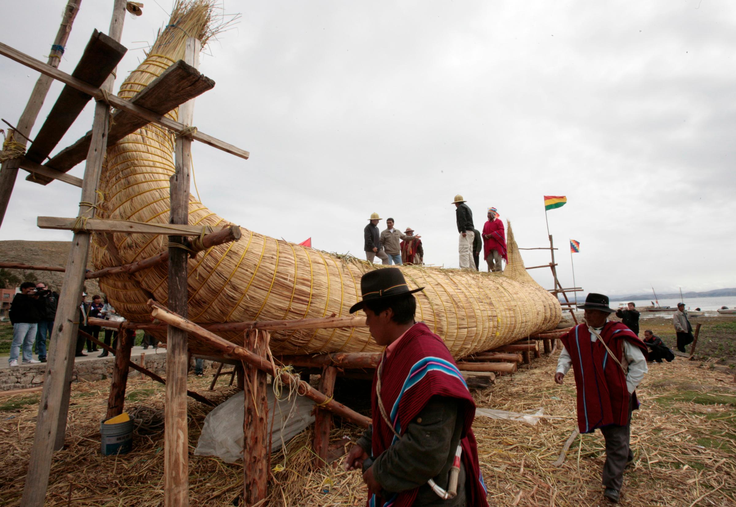 Members of the Limachi family, and others from the community living along the shores of Lake Titacaca, inspect a reed boat in Suriqui island on Lake Titicaca