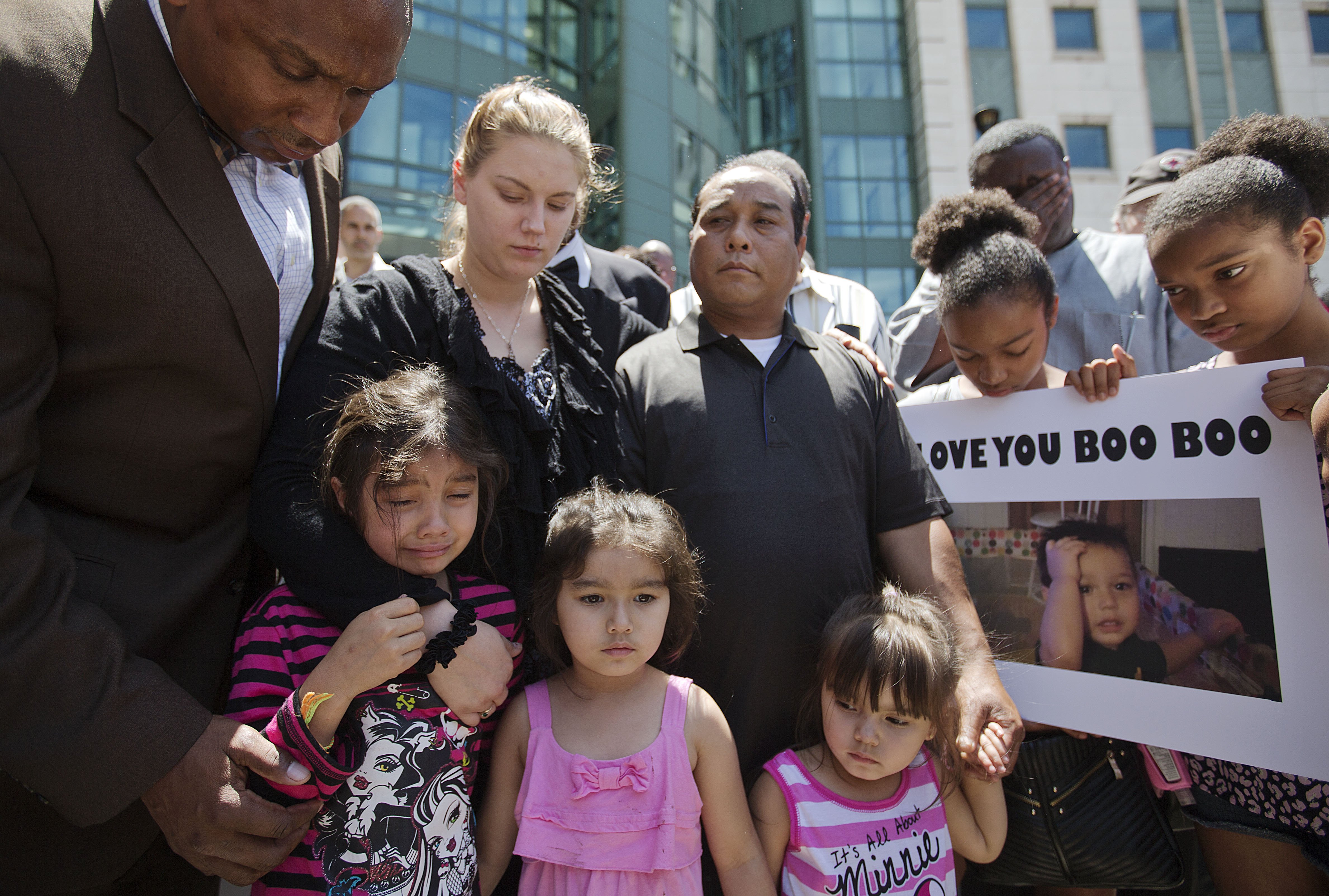 Alecia and Boun Khan Phonesavanh (center), the parents of 19-month-old Bounkham Phonesavanh who was severely burned by a flash grenade during a SWAT drug raid, attend a vigil with their daughters outside Grady Memorial Hospital where he is undergoing treatment, on June 2, 2014, in Atlanta. (David Goldman—AP)