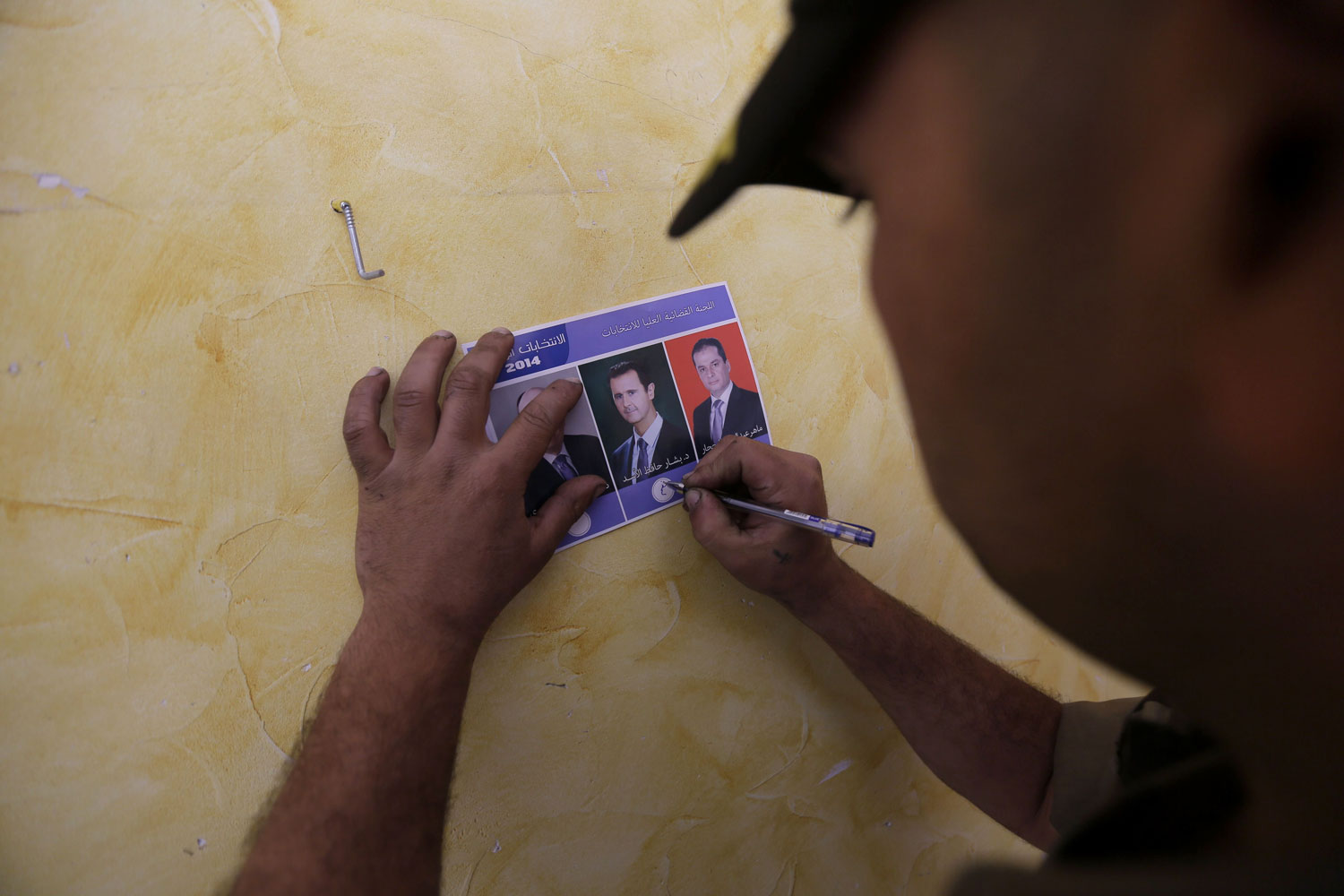 A Syrian man prepares to cast his vote at a polling station at the Umm al-Zunnar church in the city of Homs, north of Damascus, on June 3, 2014.