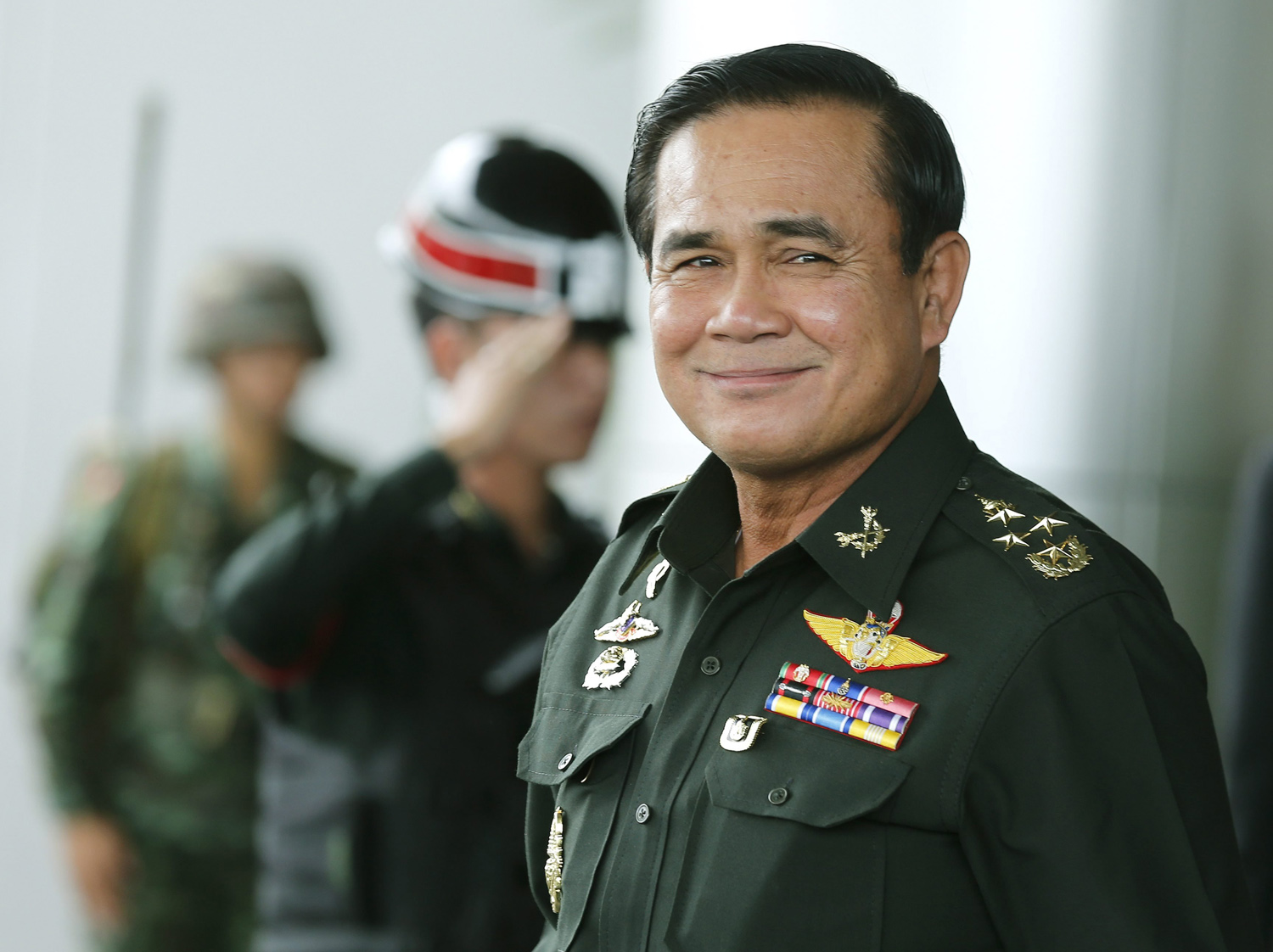 Thai army chief and junta head General Prayuth Chan-ocha smiles as he leave after the meeting of the 2015 national budget at the Army Club in Bangkok, June 13, 2014.
