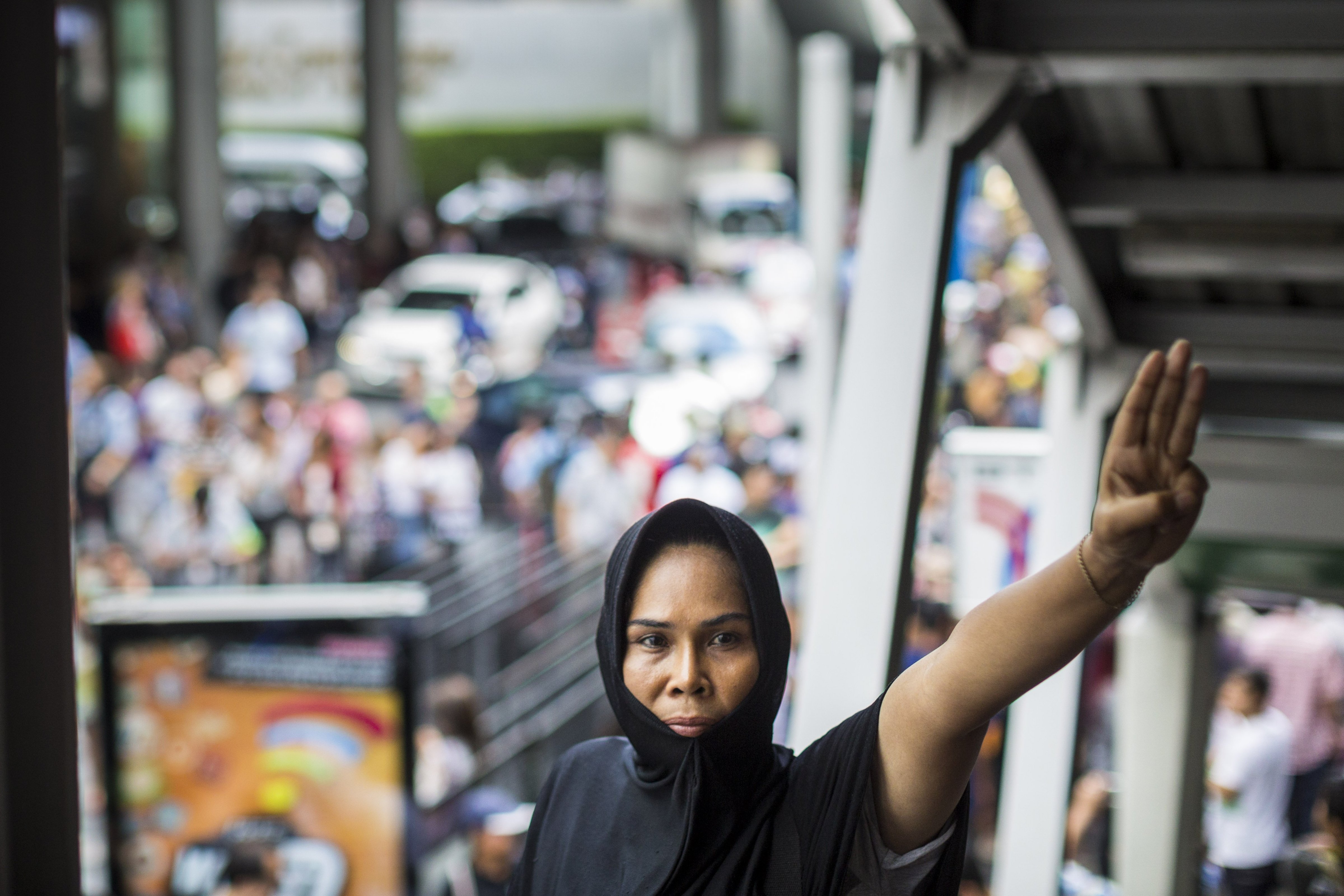 A woman holds up a three fingered salute during a protest against the Thai military coup at Terminal 21, a popular shopping mall in Bangkok, on June 1, 2014.