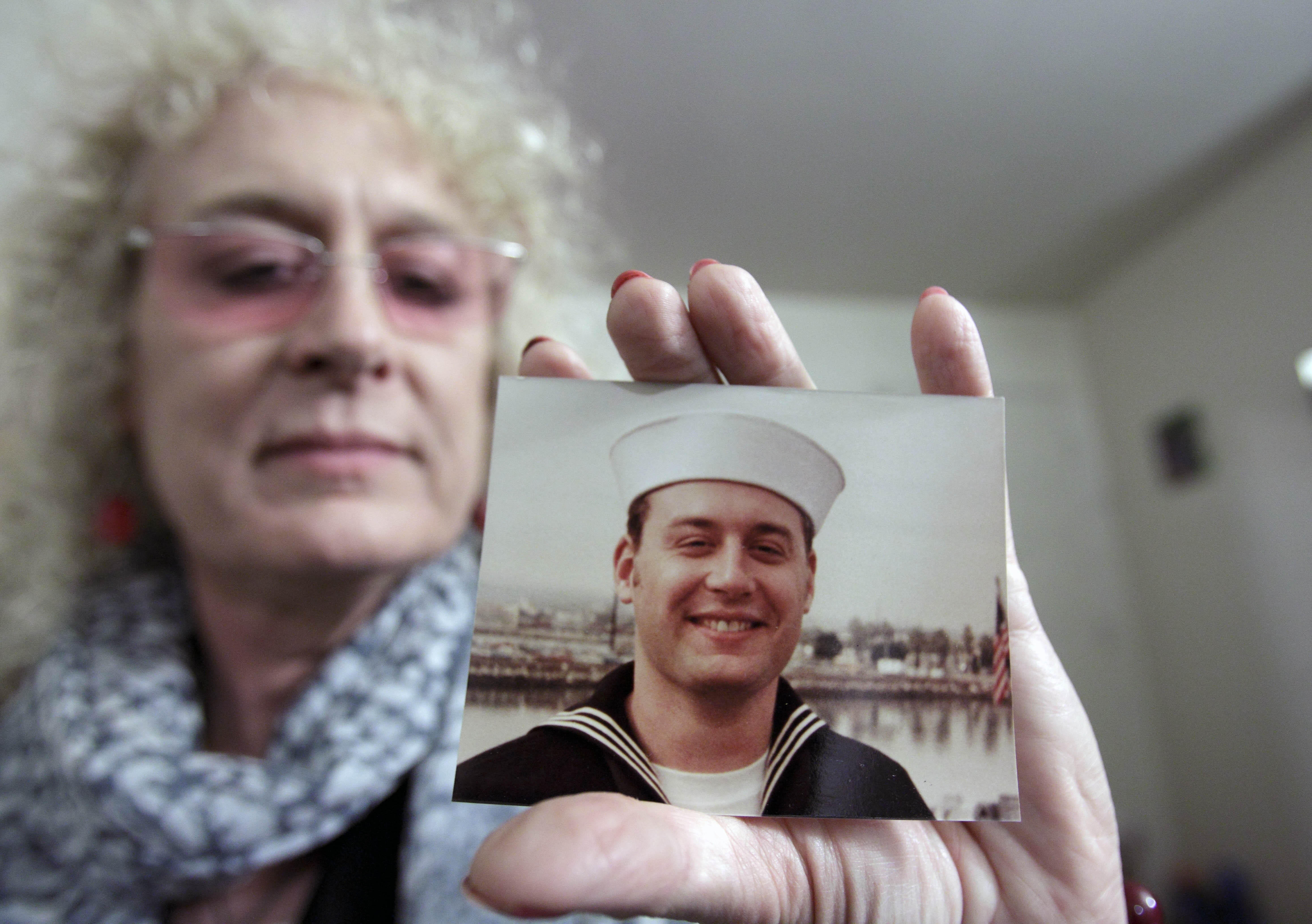 Autumn Sandeen holds a November, 1980 picture of herself as a man and navy seaman recruit on Nov. 23, 2010 in San Diego. (Gregory Bull—AP)