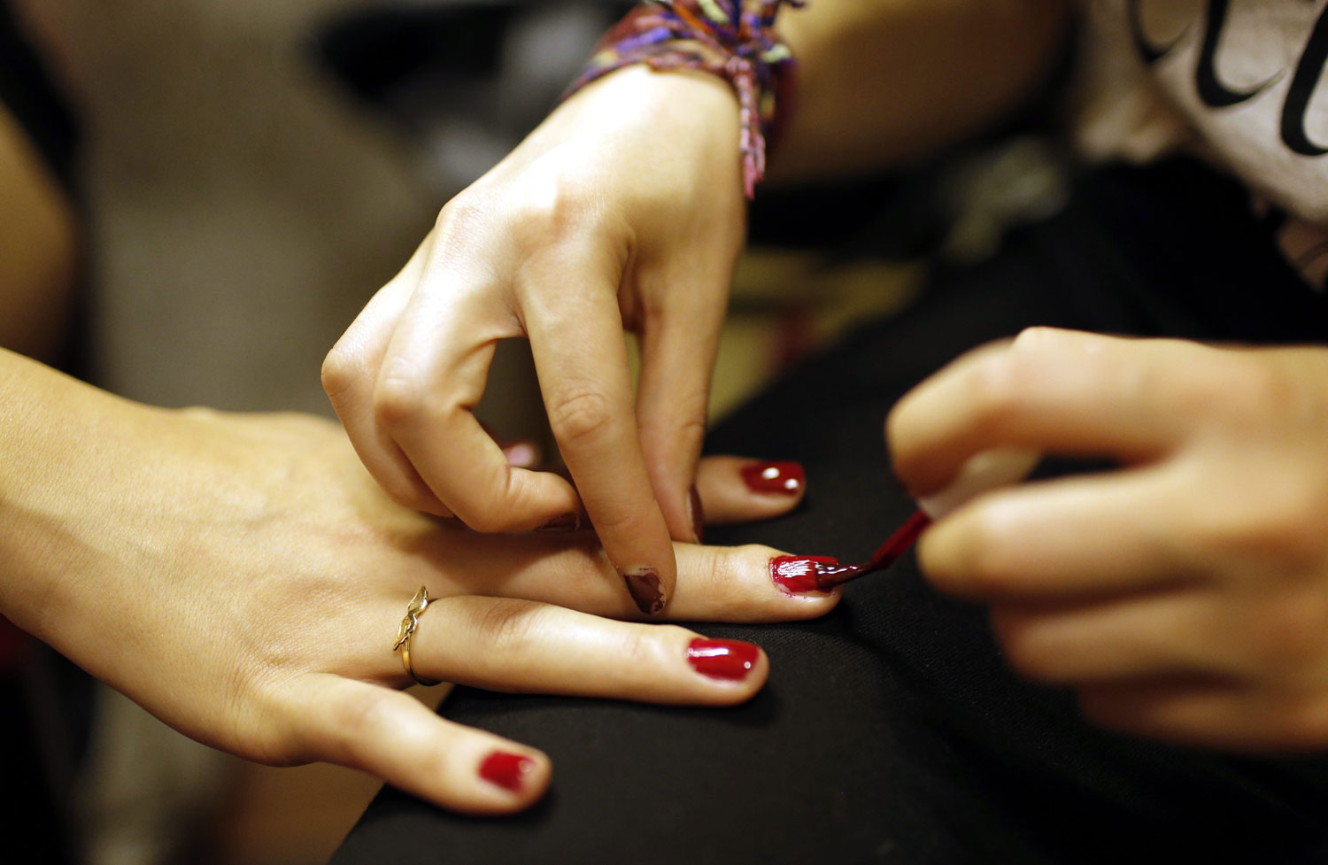 A contestant gets a manicure as other contestants prepare backstage in Istanbul on June 21, 2014.