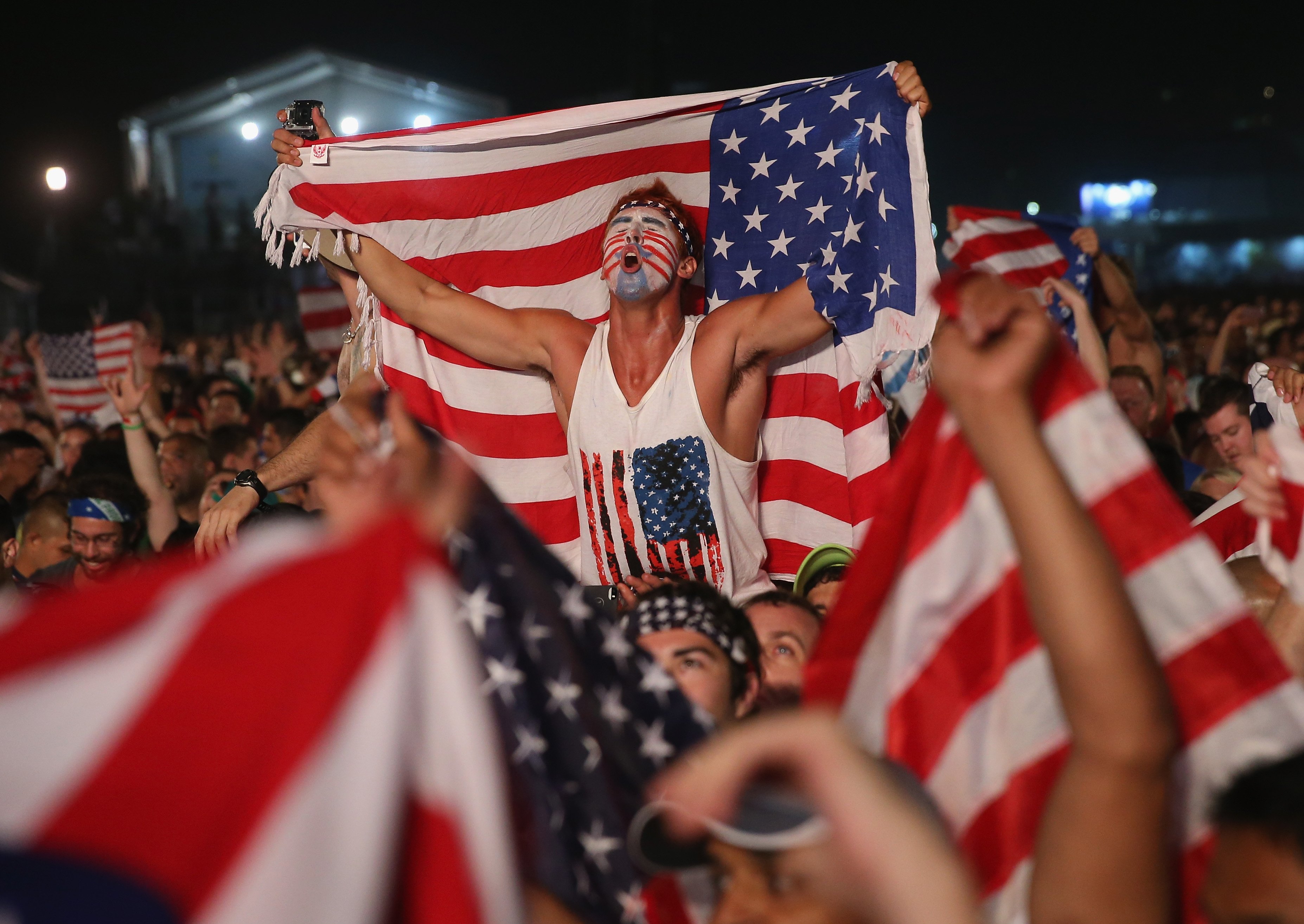 American soccer fans react to their team beating Ghana 2-1 as they watch on a large screen at the FIFA World Cup Fan Fest on Copacabana beach on June 16, 2014 in Rio de Janeiro.