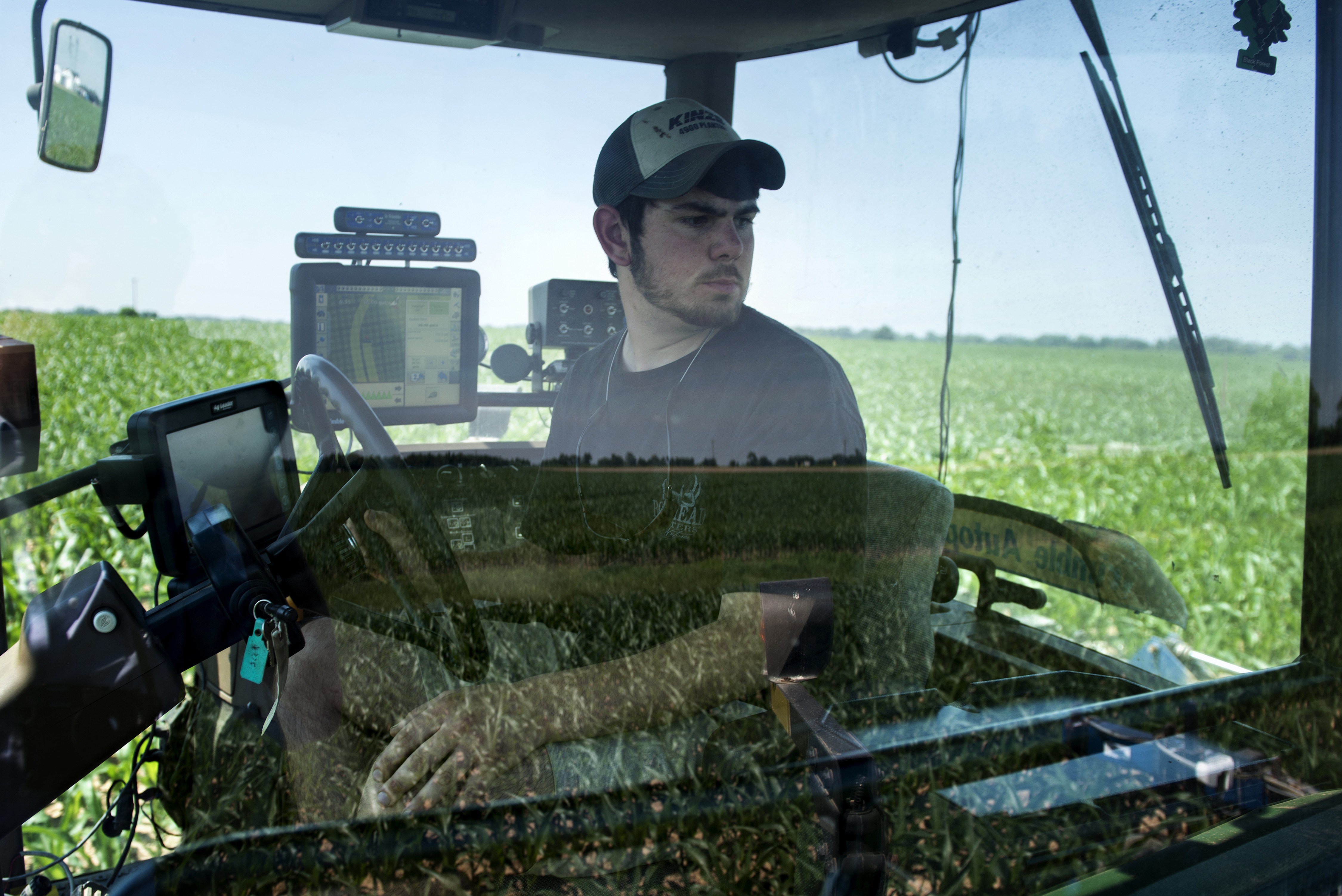 Andrew Isaacson watches from the cockpit of a tractor in a corn field as screens show where he has fertilized at the Little Bohemia Creek farm on June 17, 2014 in Warwick, Md. (Brendan Smialowski—AFP/Getty Images)