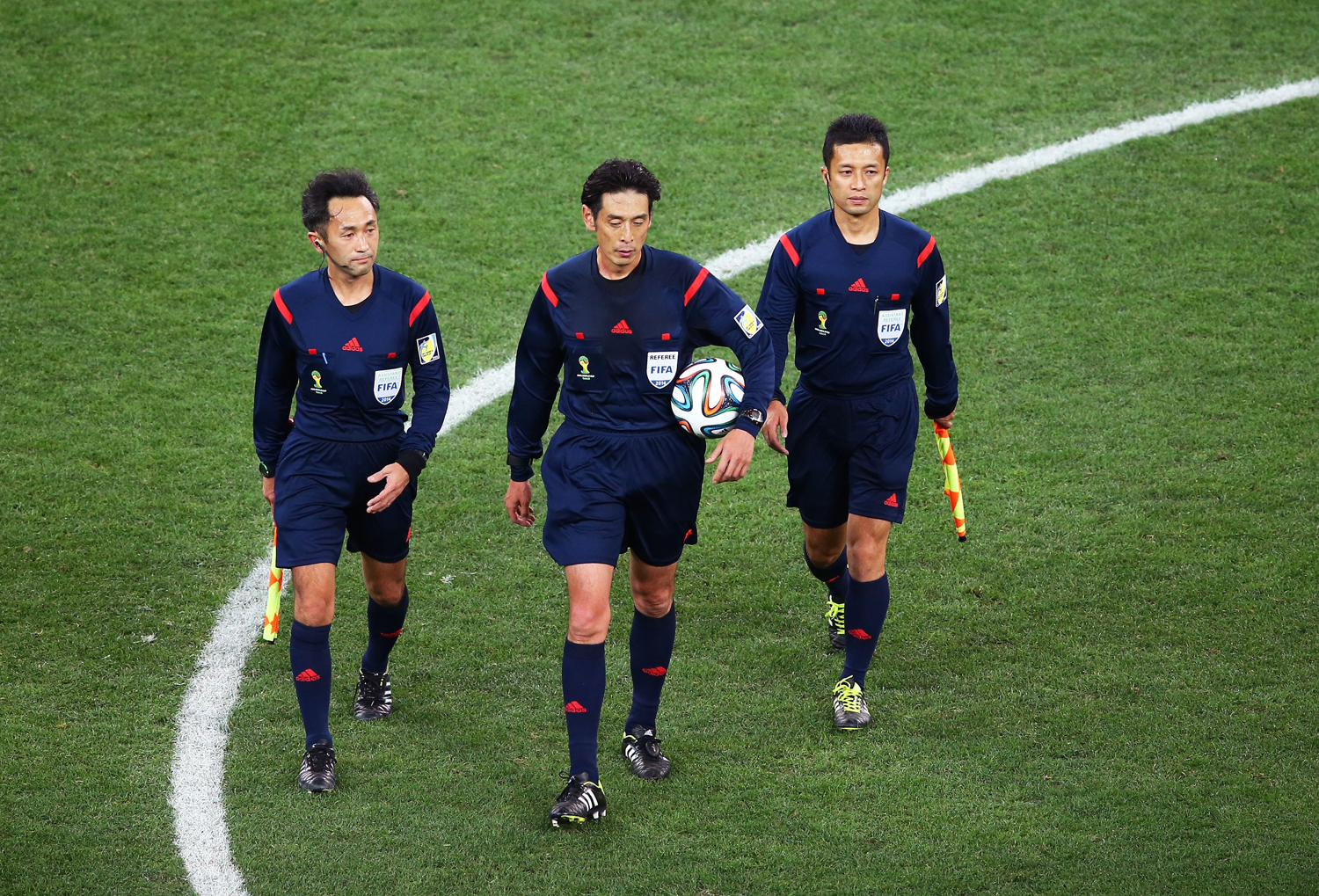 Assistant referee Toshiyuki Nagi, referee Yuichi Nishimura and assistant referee Toru Sagara of Japan walk on the field at the end of the match during the 2014 FIFA World Cup Brazil Group A match between Brazil and Croatia at Arena de Sao Paulo on June 12, 2014 in Sao Paulo.