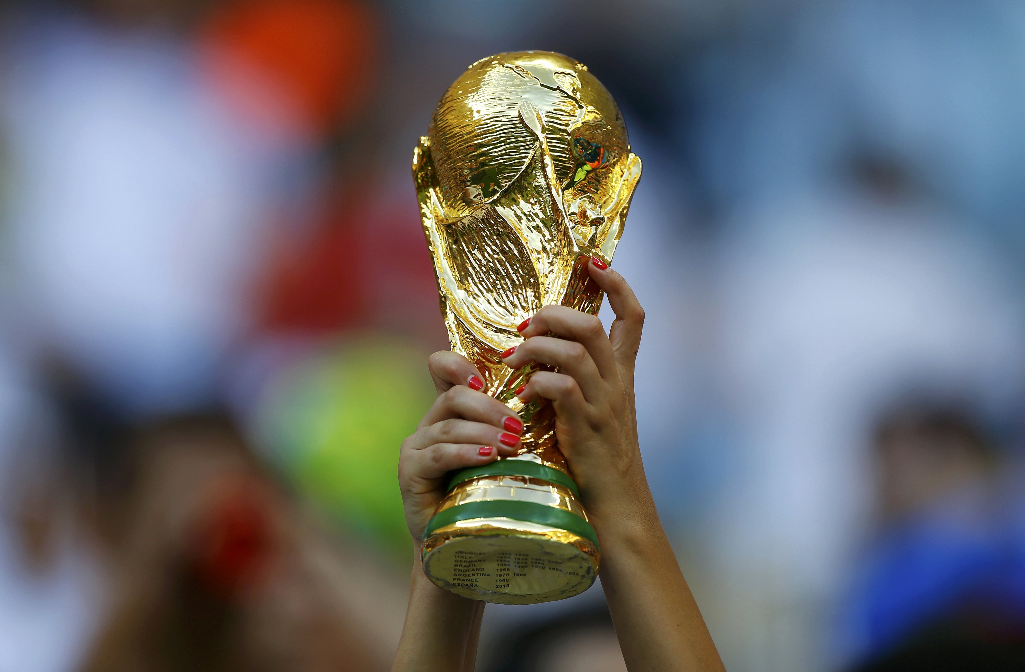 A fan holds up a trophy before the 2014 World Cup Group D soccer match between England and Italy at the Amazonia arena in Manaus on June 14, 2014.