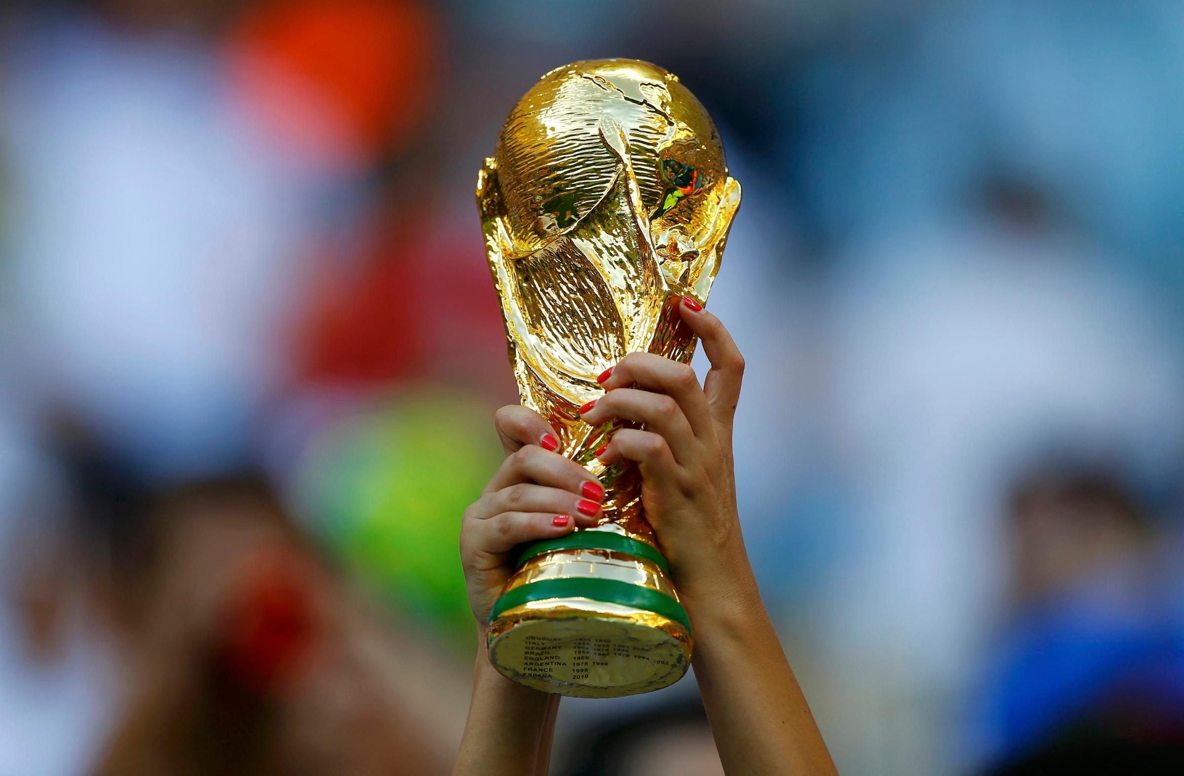 A fan holds up a trophy before the 2014 World Cup Group D soccer match between England and Italy at the Amazonia arena in Manaus on June 14, 2014.