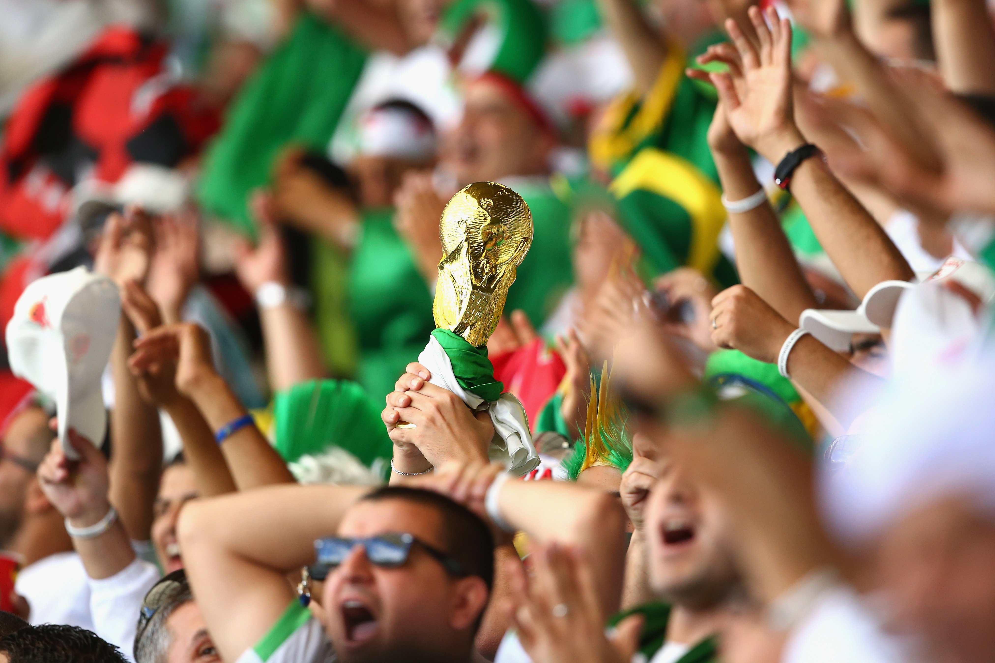 A fan holds up a replica of the World Cup trophy prior to the 2014 FIFA World Cup Brazil Group H match between Belgium and Algeria at Estadio Mineirao on June 17, 2014 in Belo Horizonte, Brazil.