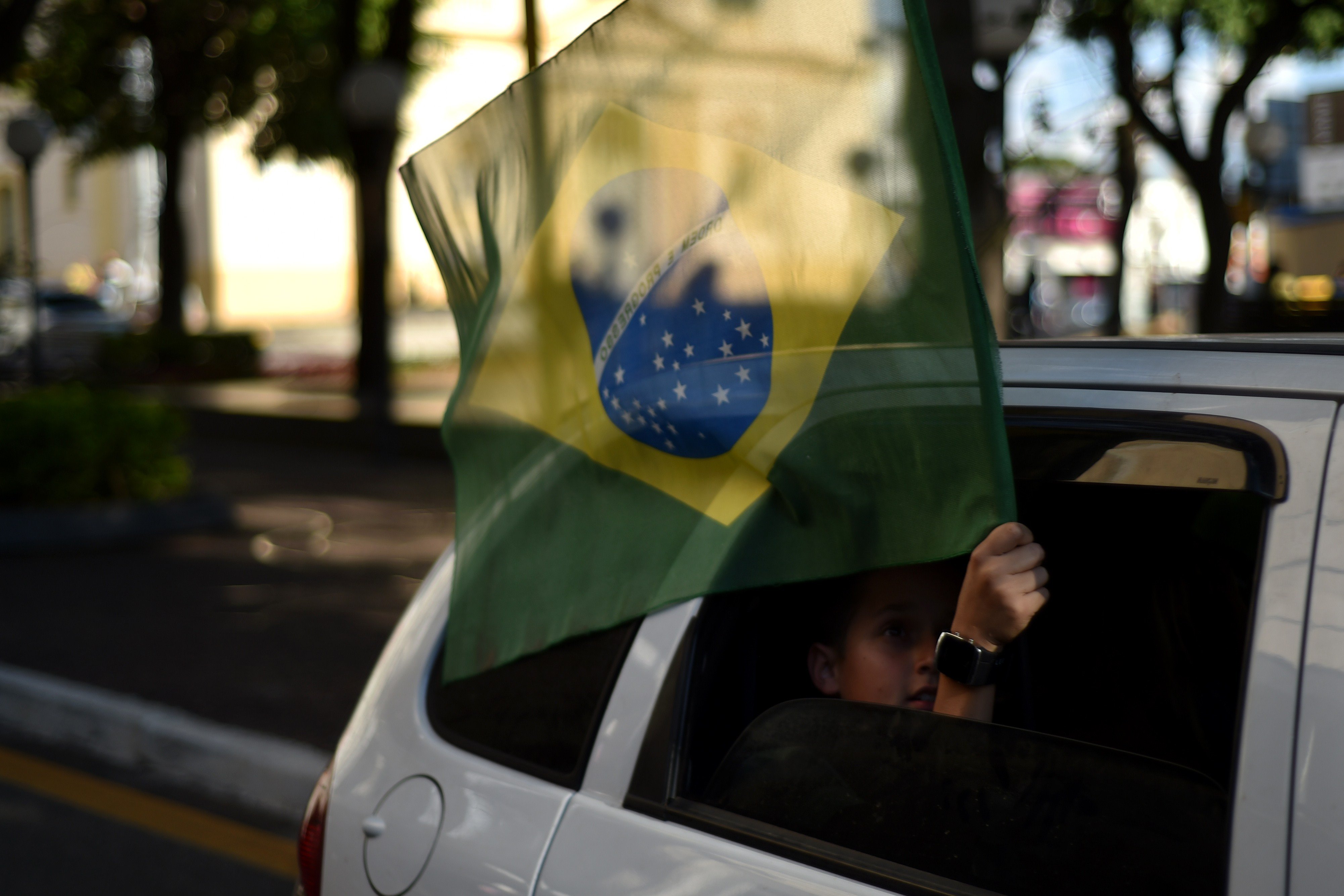 A supportersof the Brazilian national football team holds a Brazilian flag out of a car window in Itu, Brazil on June 12, 2014.