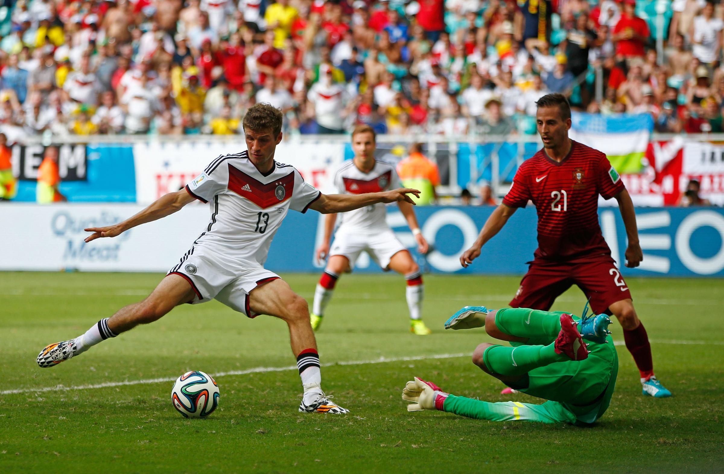 Thomas Mueller of Germany shoots and scores his team's fourth goal and completes his hat trick past Rui Patricio of Portugal during the 2014 FIFA World Cup Brazil Group G match between Germany and Portugal at Arena Fonte Nova on June 16, 2014 in Salvador, Brazil.