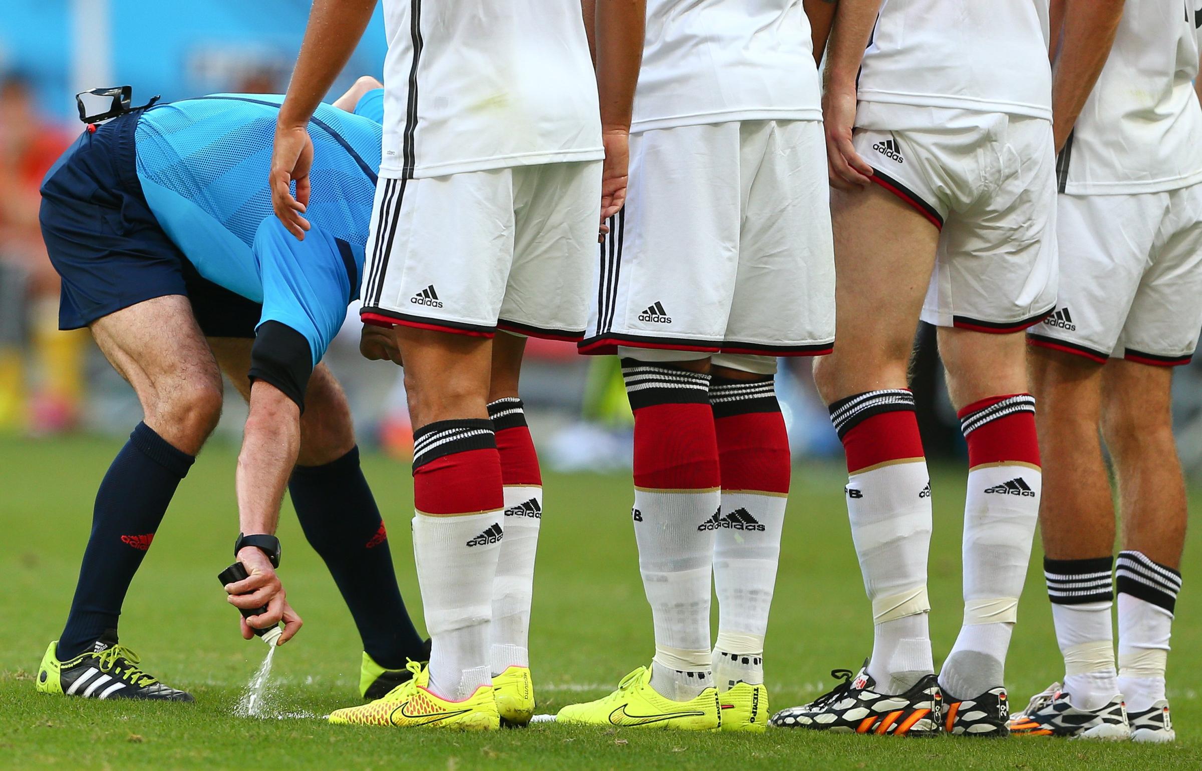 Referee Milorad Mazic uses vanishing spray to mark where the Germany wall must stand for a Portugal free kick during the 2014 FIFA World Cup Brazil Group G match between Germany and Portugal at Arena Fonte Nova.