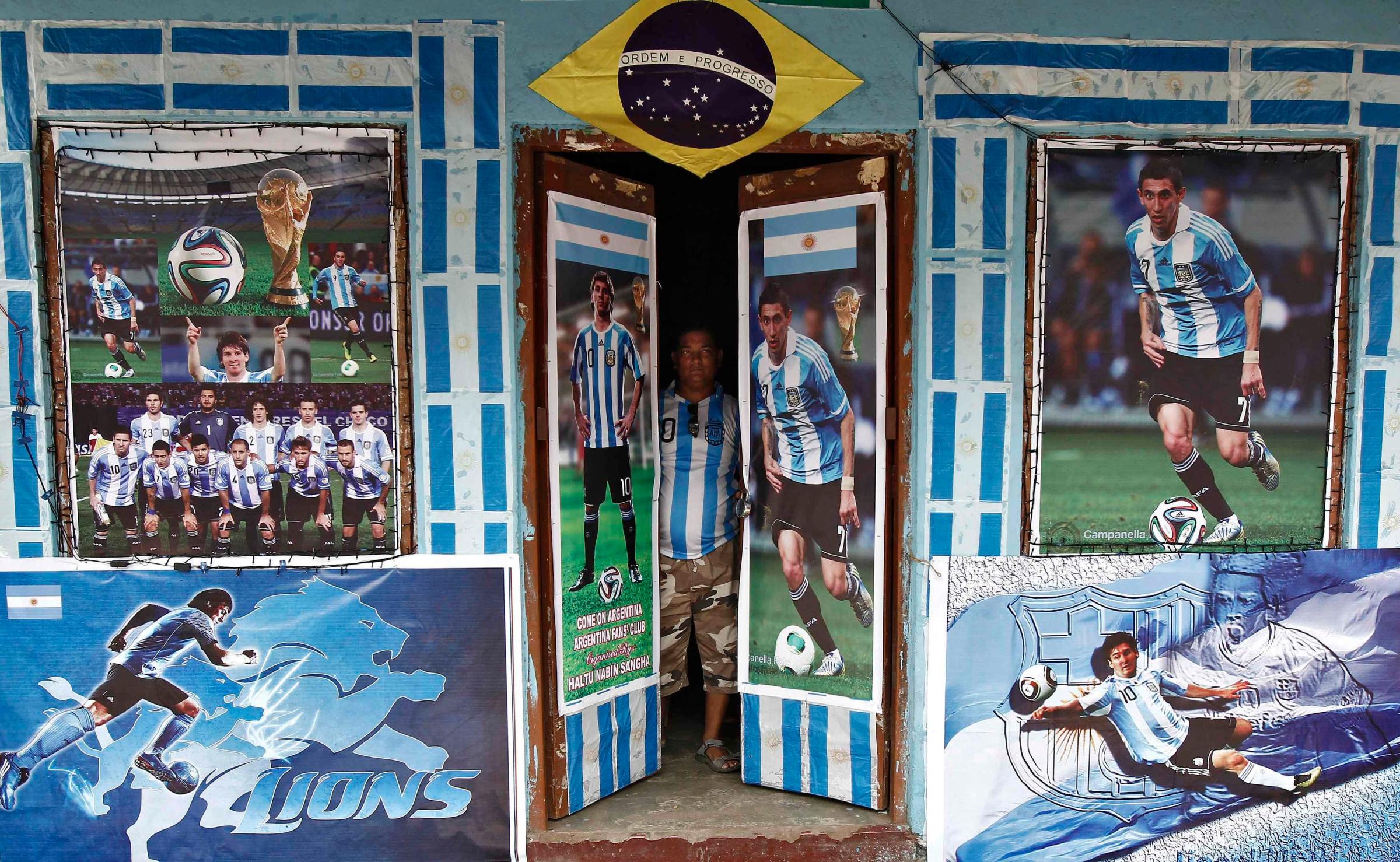 A fan of Argentina looks out from his local soccer club decorated with pictures of Argentin soccer players ahead of the 2014 World Cup, in Kolkata on June 10, 2014.