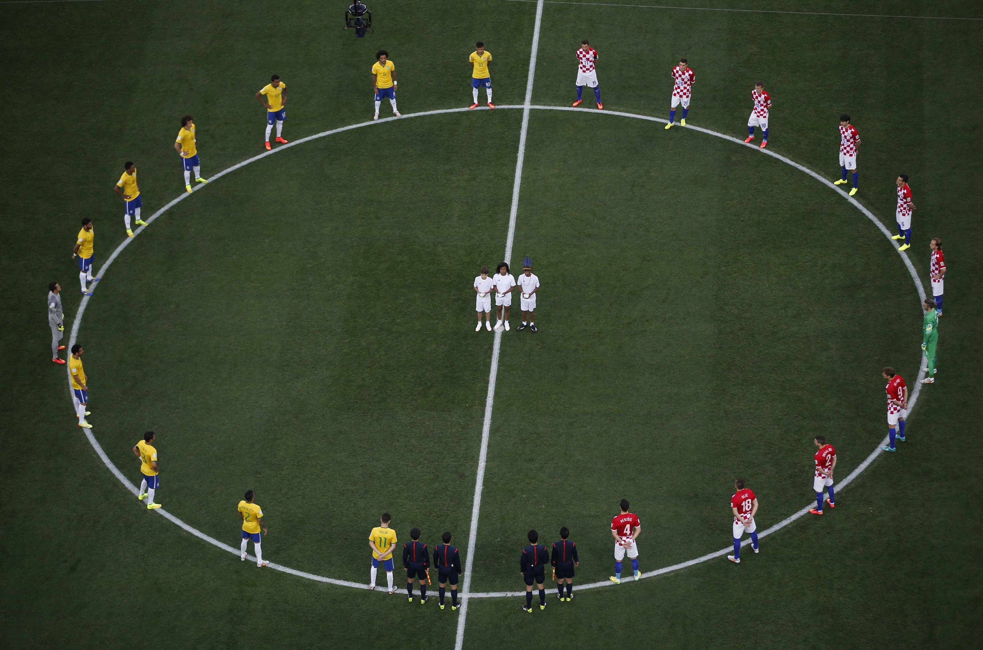Brazil and Croatia players stand in a circle as doves are released before kickoff at the 2014 World Cup opening match at the Corinthians arena in Sao Paulo on June 12, 2014.