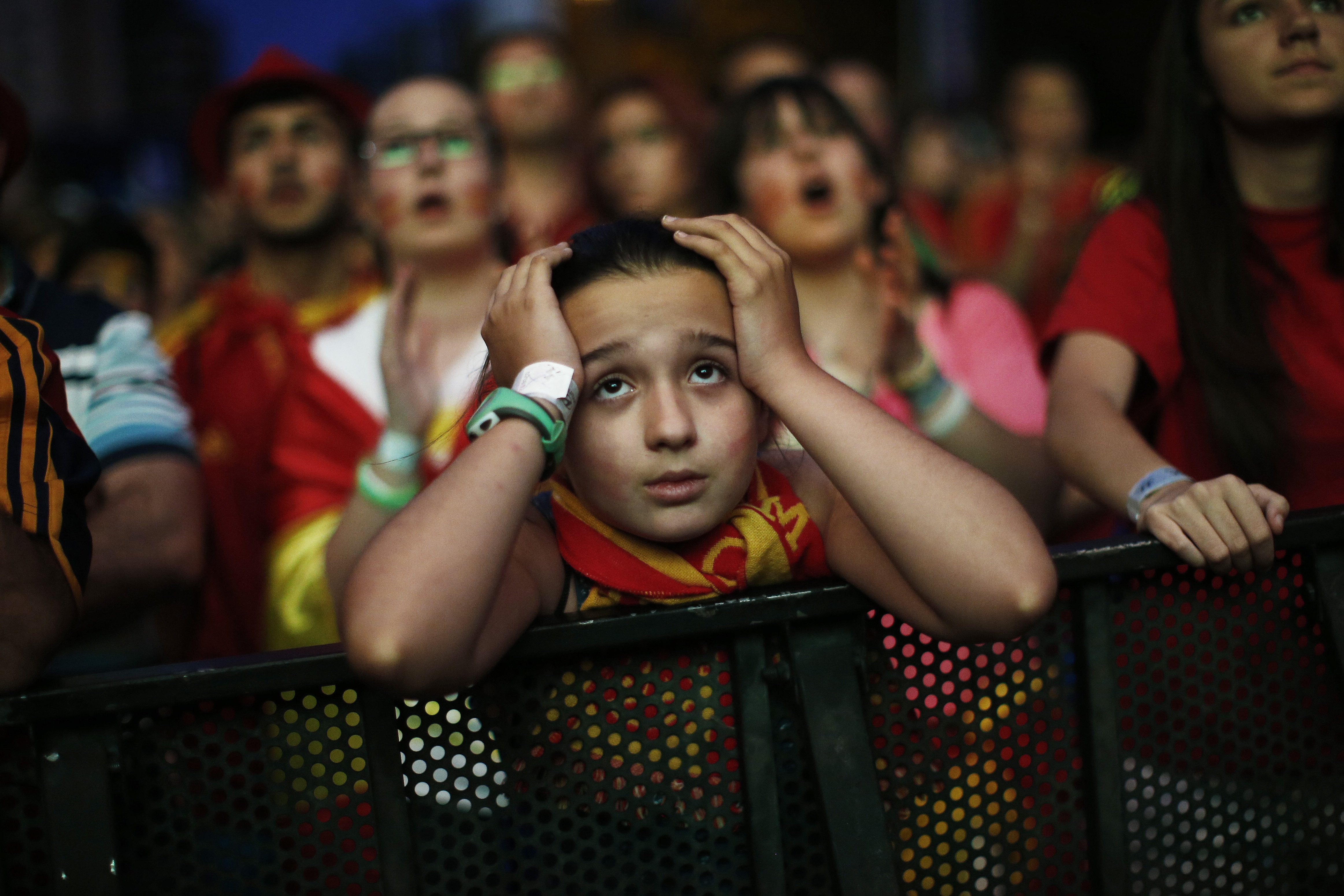 A Spanish soccer fan holds her head as she watches, on a giant display, the World Cup soccer match between Spain and Chile, in Madrid, Spain, Wednesday, June 18, 2014. (AP Photo/Andres Kudacki)