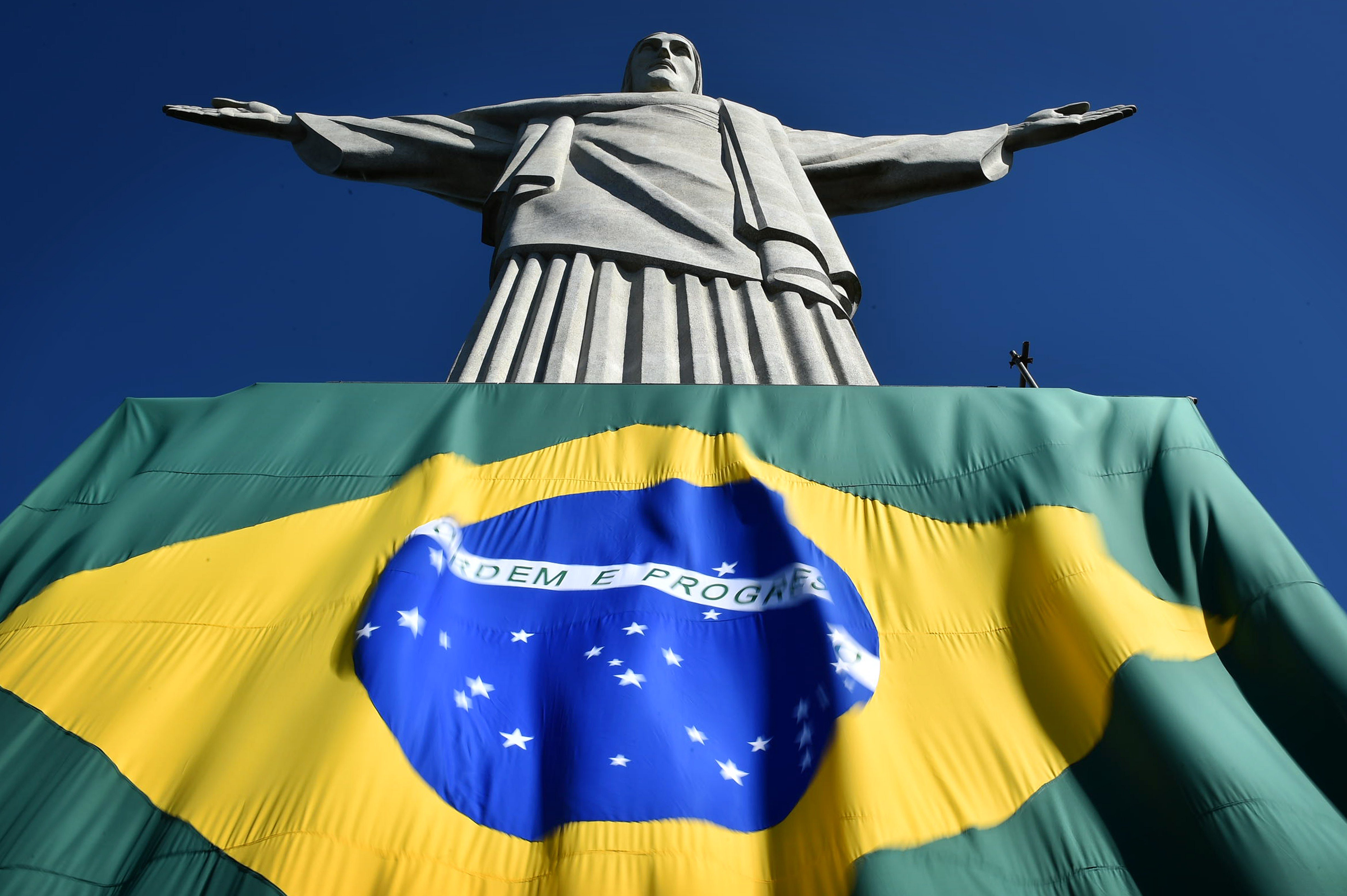 The Brazilian flag is seen at the base of the statue of the Christ the Redeemer on top of Corcovado hill in Rio de Janeiro on June 12, 2014.