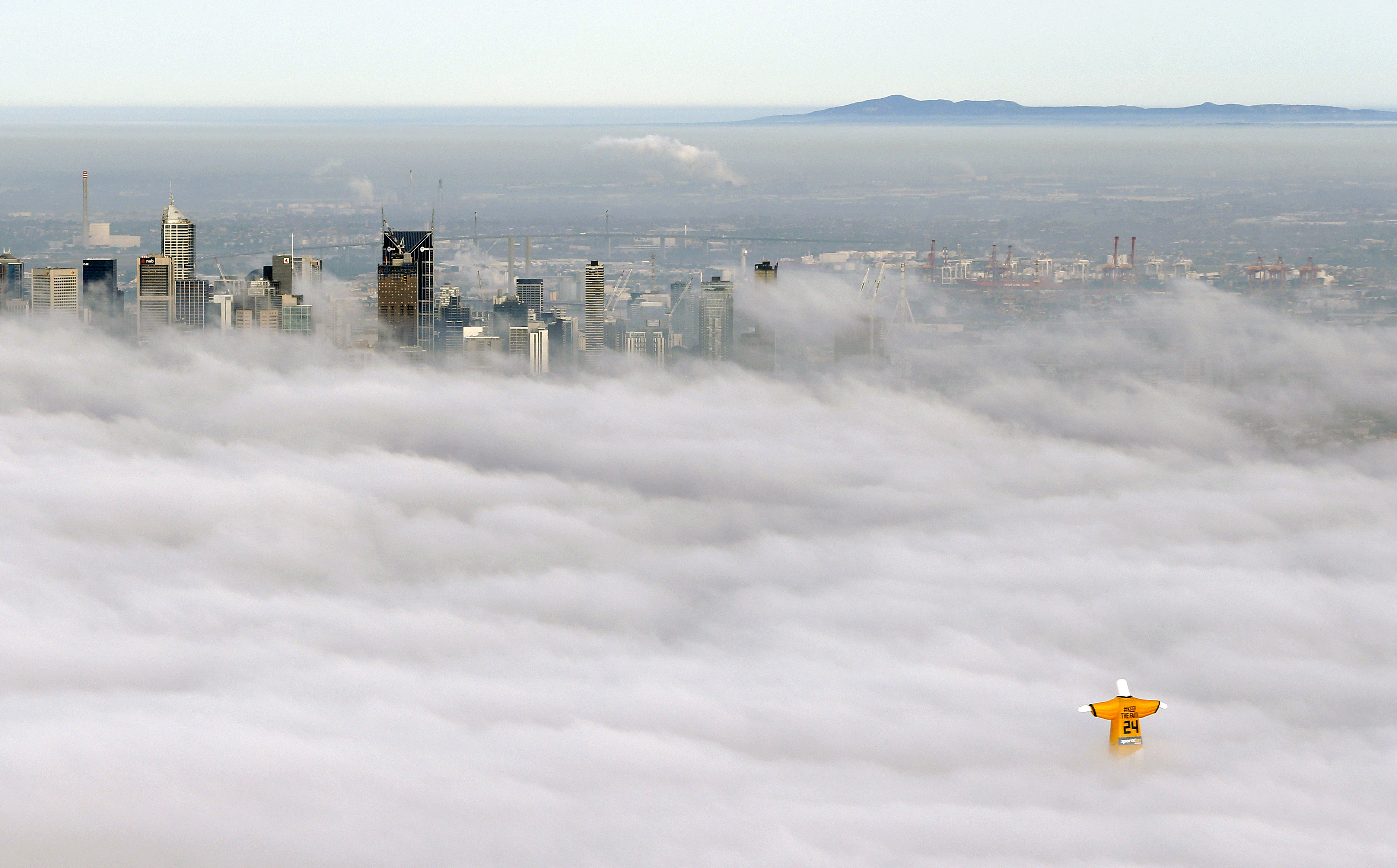 A hot air balloon in the likeness of Brazil's Christ The Redeemer statue, wearing the colors of Australia's soccer team floats through clouds over the Melbourne skyline on June 10, 2014.