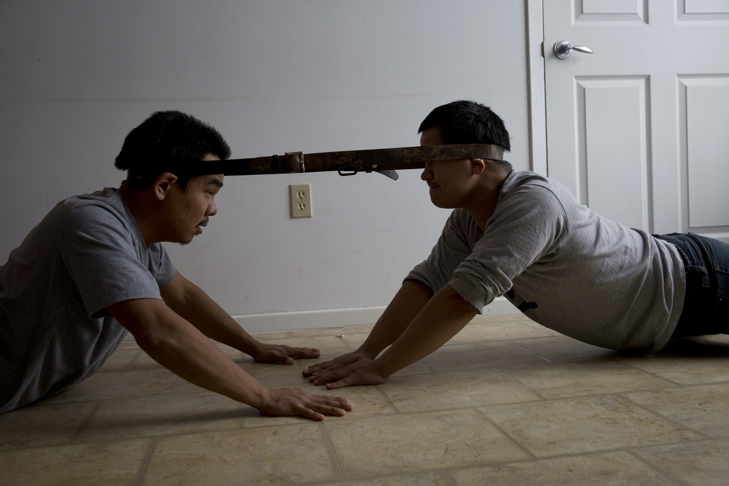 ARVIAT, CANADA - OCTOBER 16  William Tiktaq (left), 28, and Brian Tagalik (right), 28, compete with each other in an Inuit head pull competition inside their home in Arviat, Canada on Oct. 16, 2013. Inuit games are played as a way to pass the time while stuck indoors during the cold arctic winters and to test and develop the skills required for hunting and arctic survival, including strength, agility, and tolerance to pain. They require very little equipment and can be played in tight spaces.  (Ed Ou/Reportage by Getty Images)