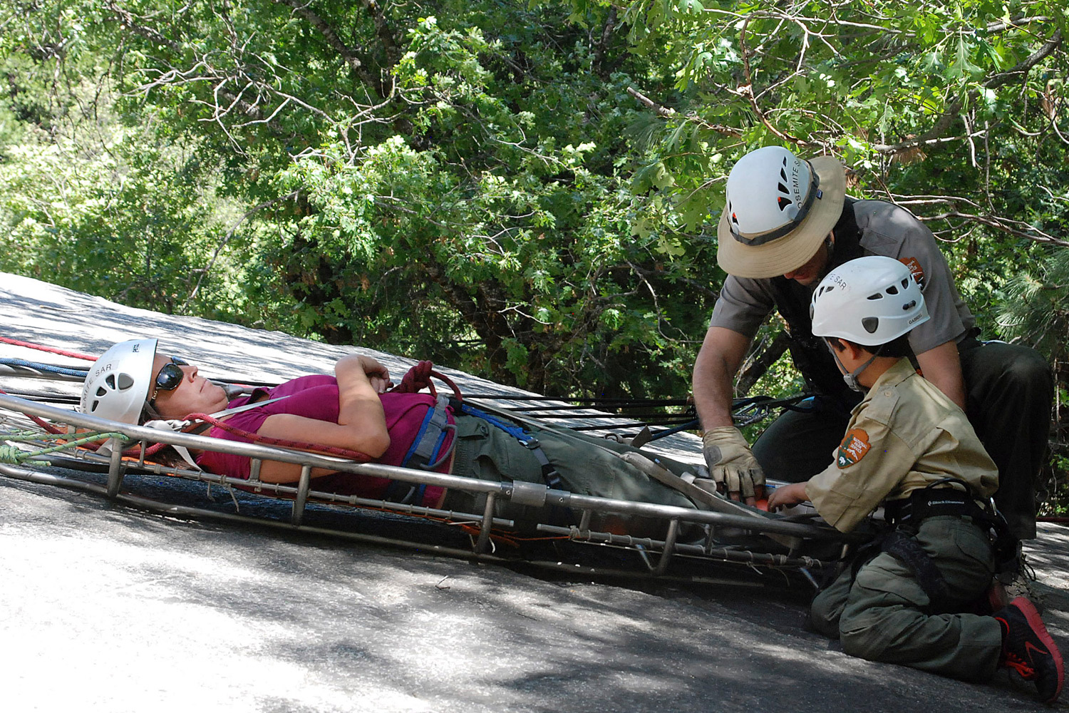 Gabriel LaVon Ying, right, learning how to assist an injured hiker during a simulated search and rescue operation with the Yosemite medical team. (National Park Service / AP)