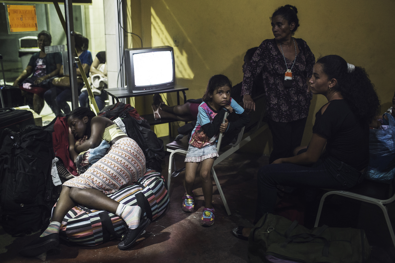 Exhaustion is the prevailing mood among departing migrants at the bus terminal in San Pedro Sula. The space is a hub for people aiming north. Honduras. July 15, 2014.