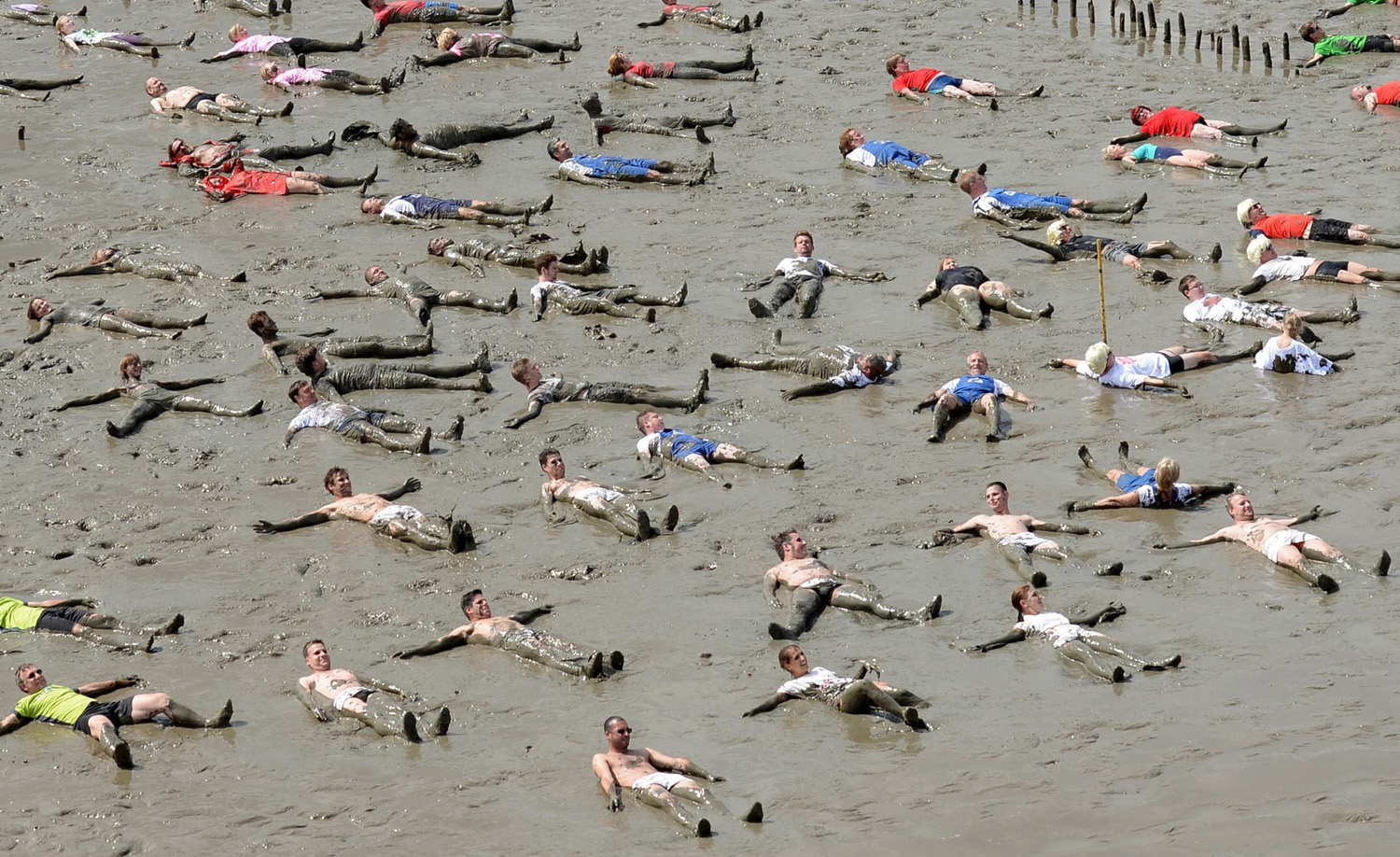 Some of the 350 participants lie on their backs in mudflats as part of a record attempt event for the 2014 Mudflat Olympics, outside of the city of Brunsbuettel, northern Germany, July 6, 2014.
