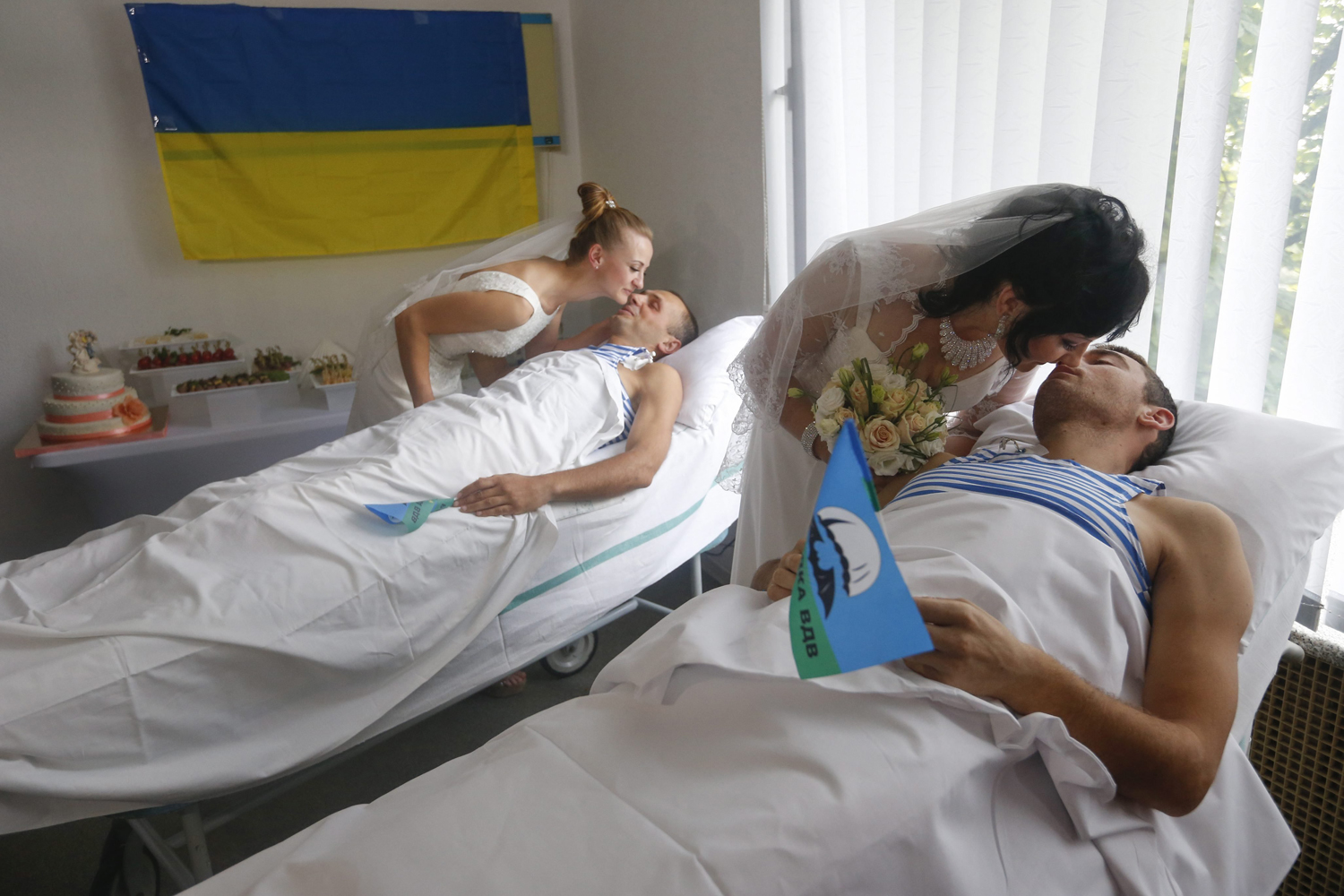 Wounded members of the Ukrainian force kiss their brides in hospital beds