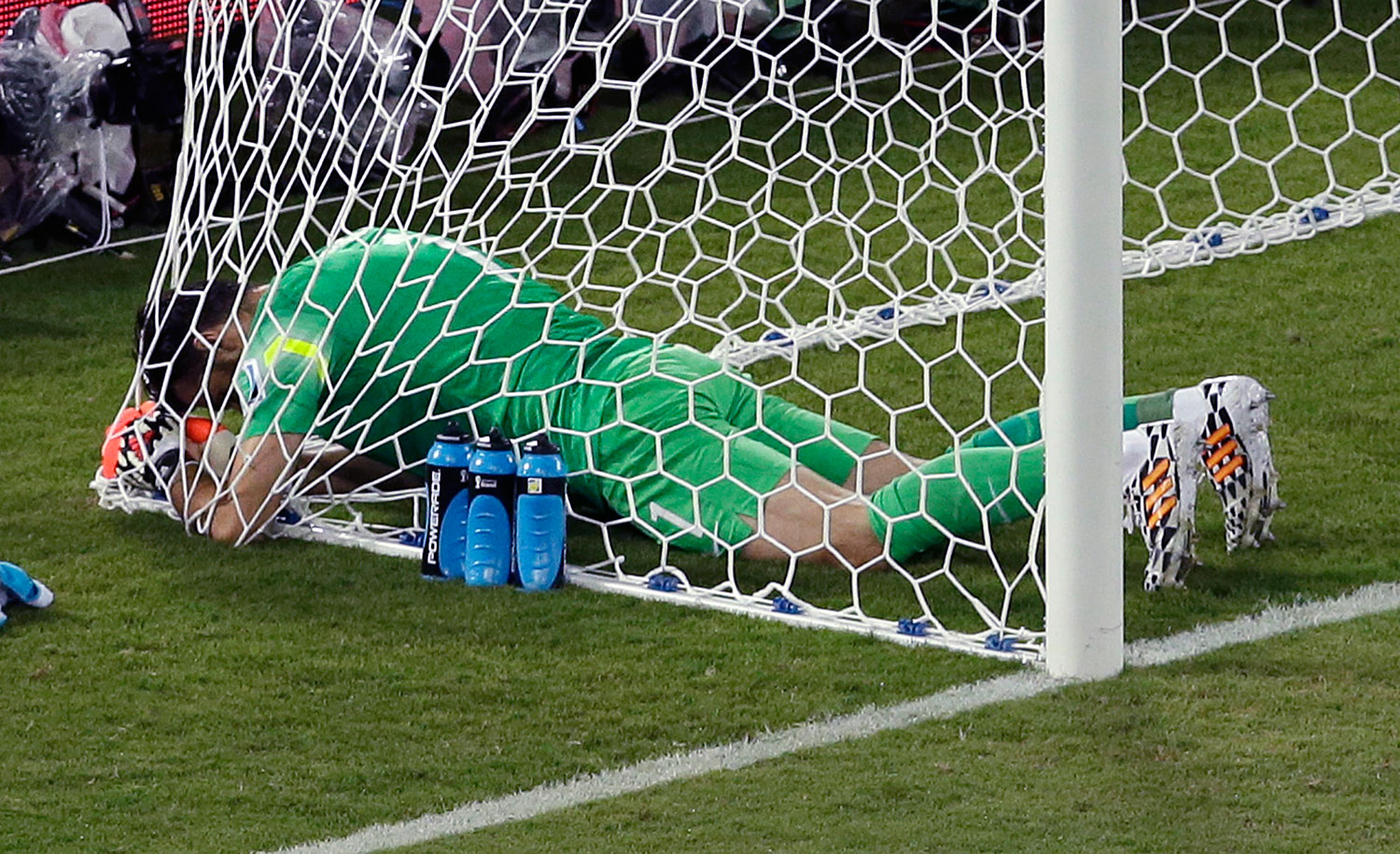 Greece's goalkeeper Orestis Karnezis sits in the net during the group C World Cup soccer match between Japan and Greece at the Arena das Dunas in Natal, Brazil on June 19, 2014.