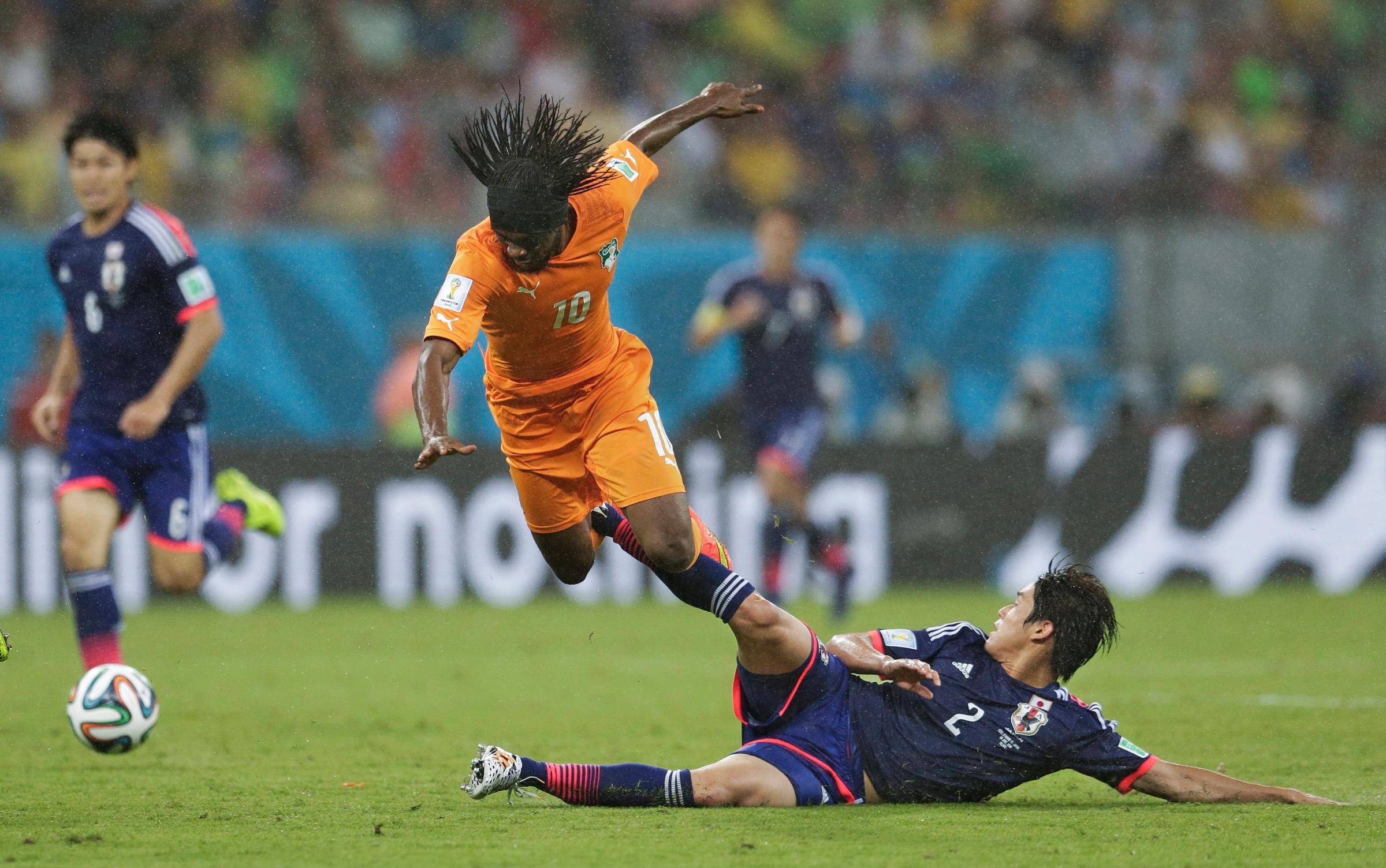 Ivory Coast's Gervinho is tripped by Japan's Atsuto Uchida during the match at the Arena Pernambuco in Recife, Brazil on June 14, 2014.