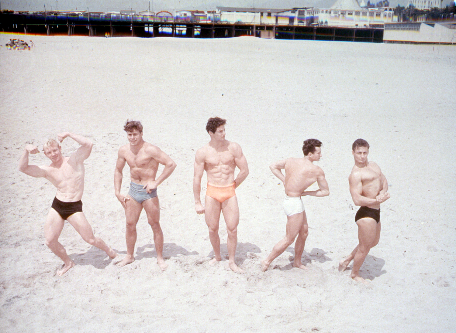 Flexing their muscles for their mutual admiration and for that of passers-by, these California youths find the days go fast on Muscle Beach at Santa Monica.