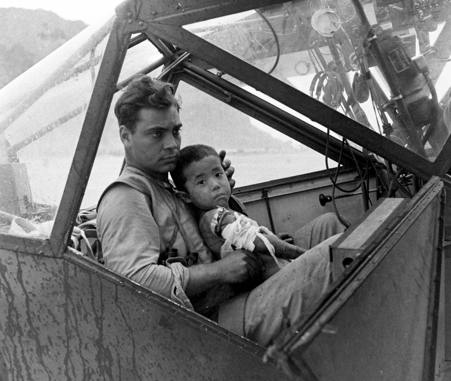 Wounded Japanese child and American pilot, Saipan, 1944.