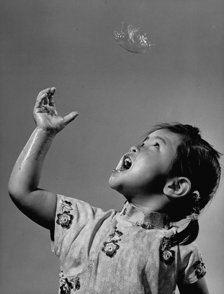 Celestine Jay Ku reacts as a soap bubble bursts above her, 1941.