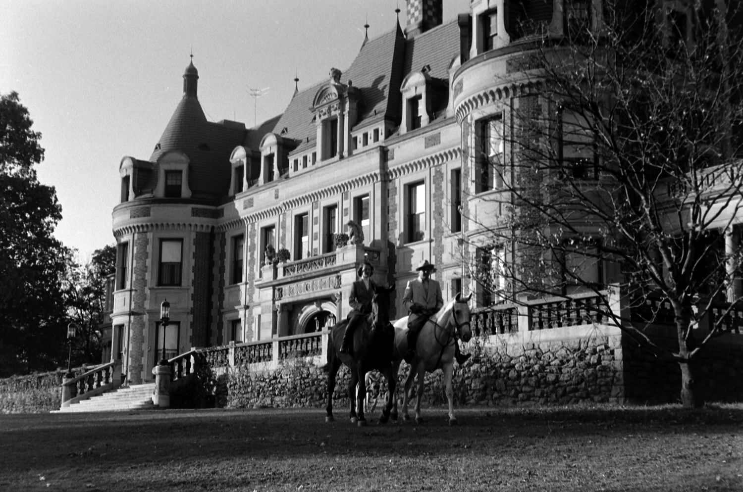 Out for the daily ride, Trudy astride Happy Landing and Gussie on Miss Budweiser amble across the lawn of the 34-room brick mansion Gussie's father erected in 1911.